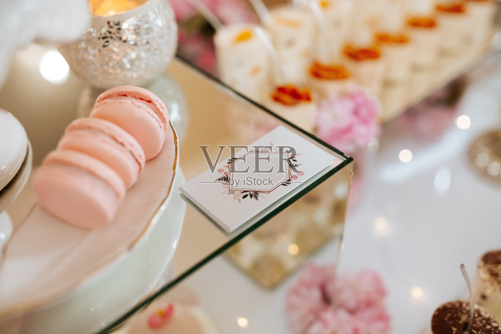 美味的婚宴糖果吧甜点桌摆满了蛋糕和糖果和鲜花中国樱花为背景的精致餐厅照片摄影图片