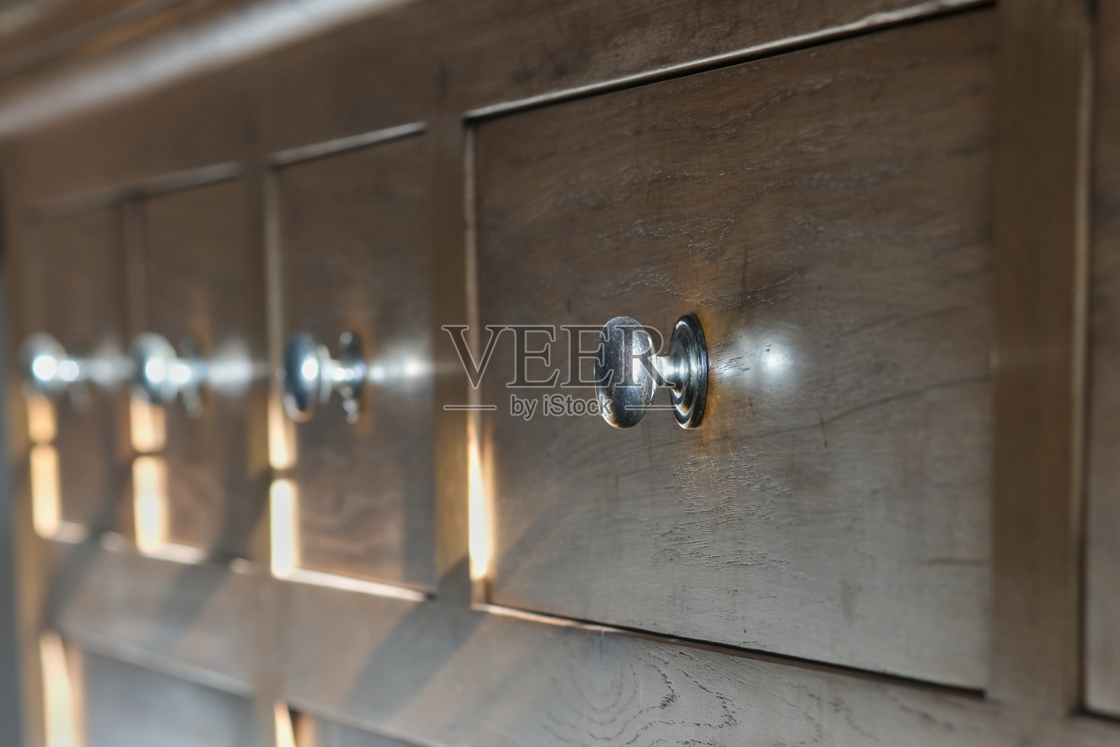 浅橡木柜上的抽屉旋钮，透视图照片摄影图片