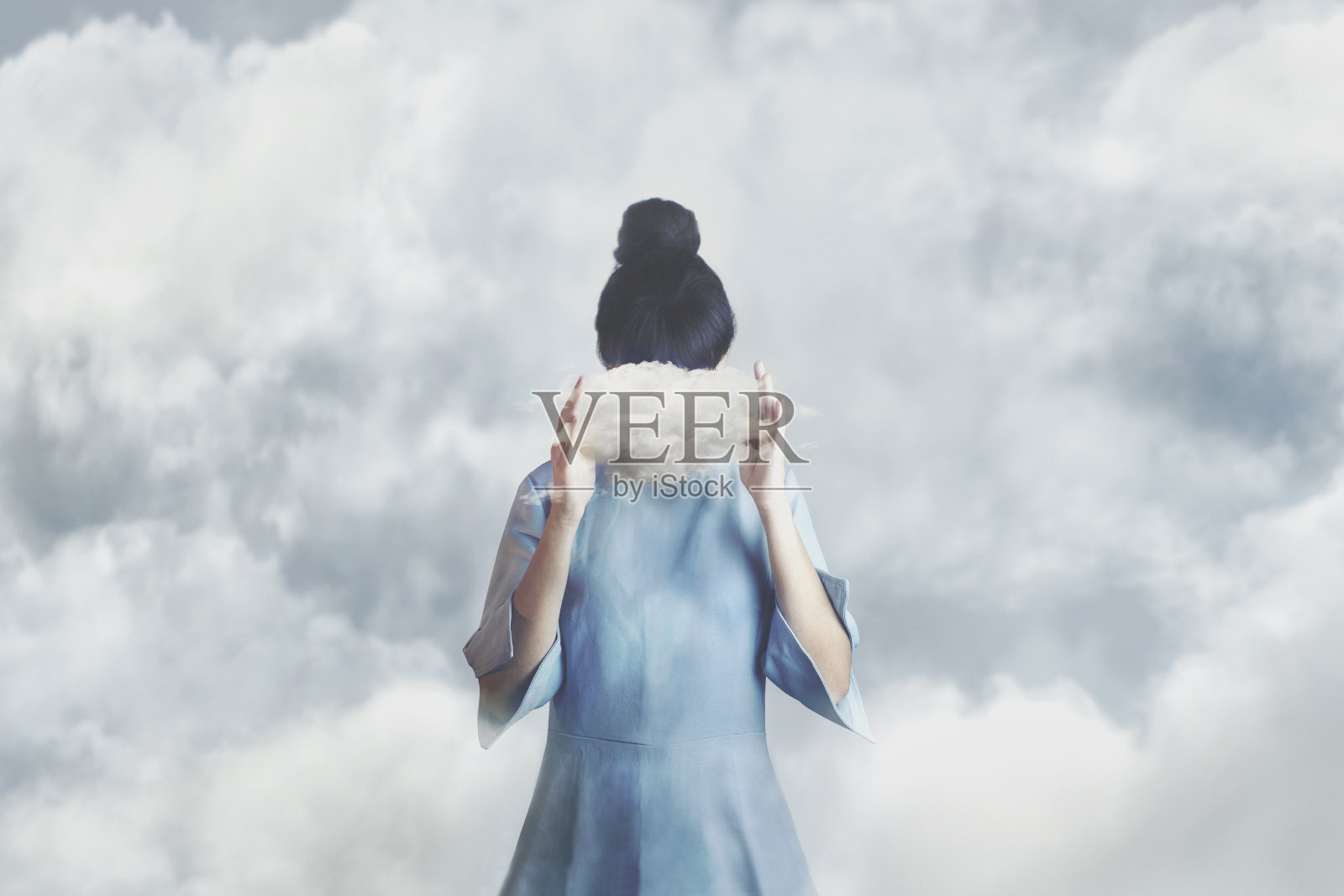 超现实的小云藏着一个女人的脸，自由的概念照片摄影图片