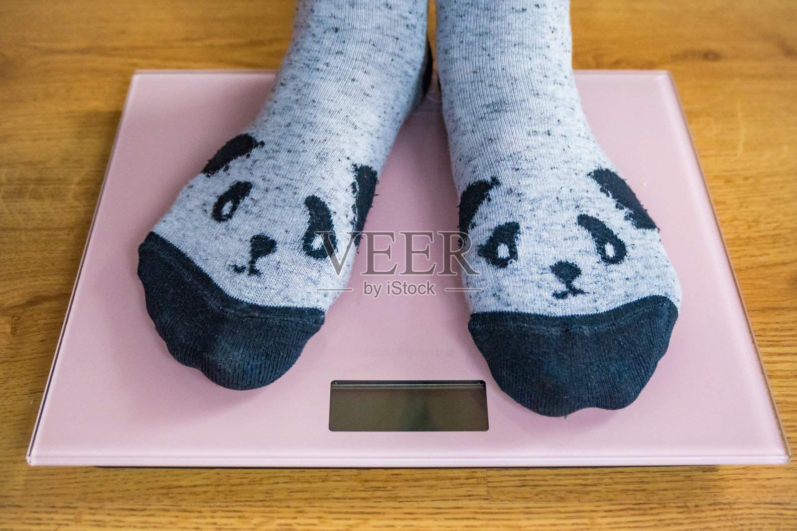 一个穿着情趣袜的女人在电子秤上称自己的体重，俯视图照片摄影图片