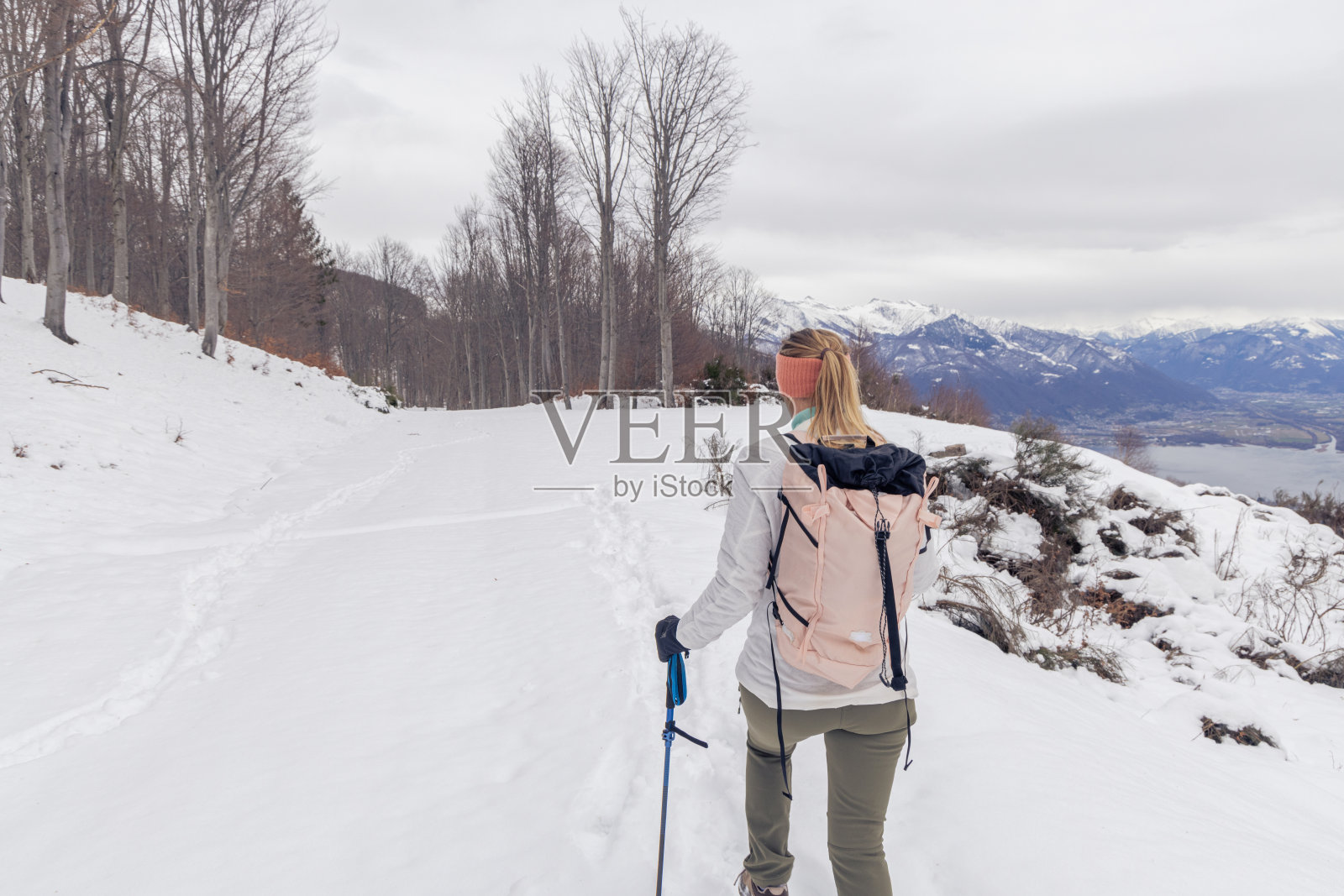 后视图，女子在雪景中徒步旅行照片摄影图片