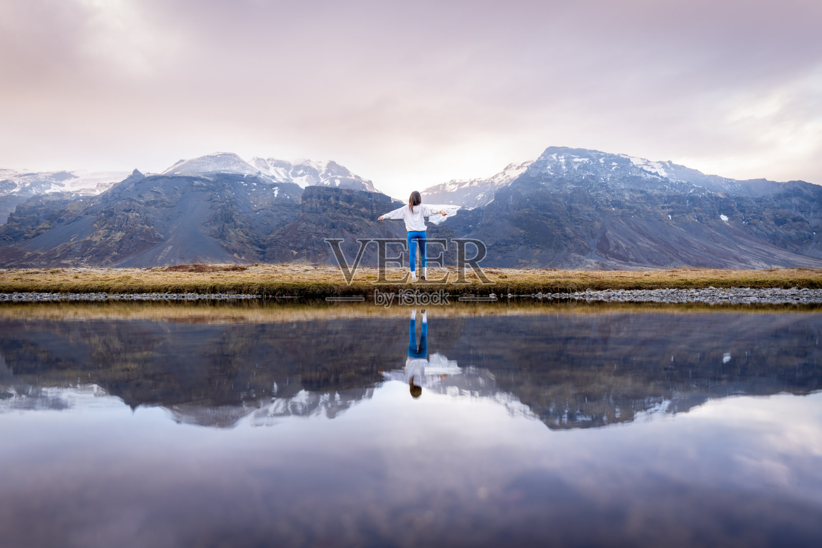 一个人站在草地和田野的水边照片摄影图片