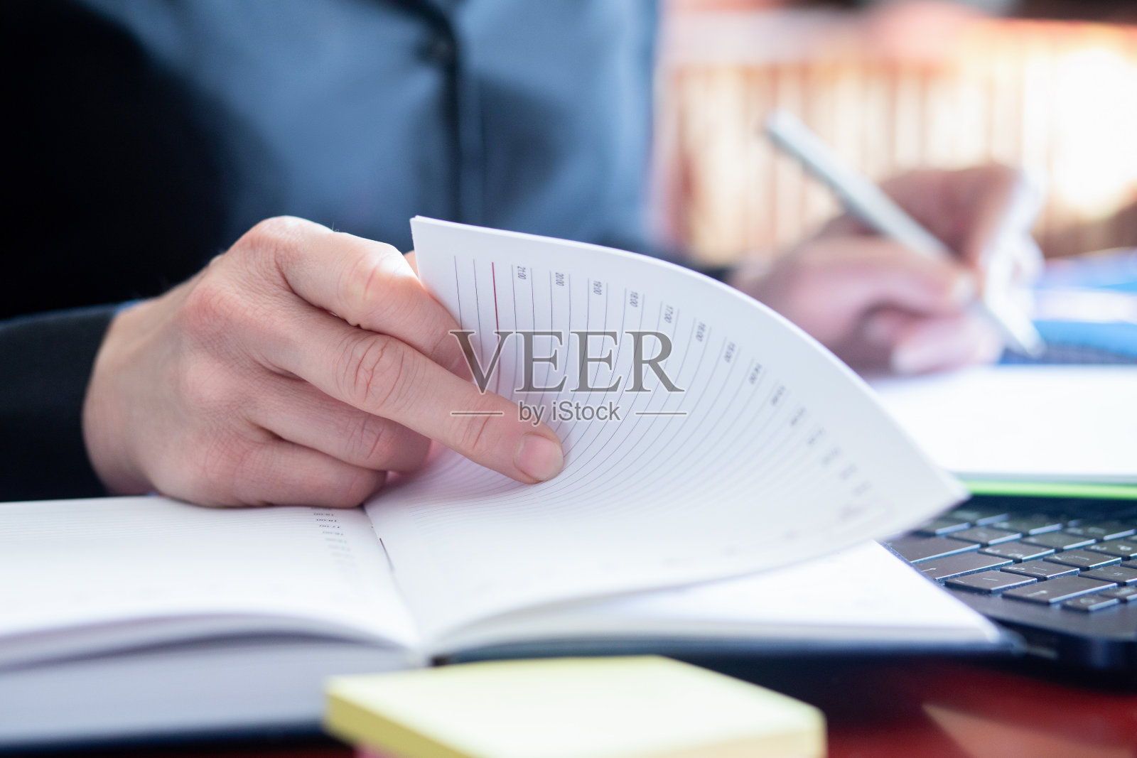 一位女商人正在翻阅商业任务日记(特写)。照片摄影图片