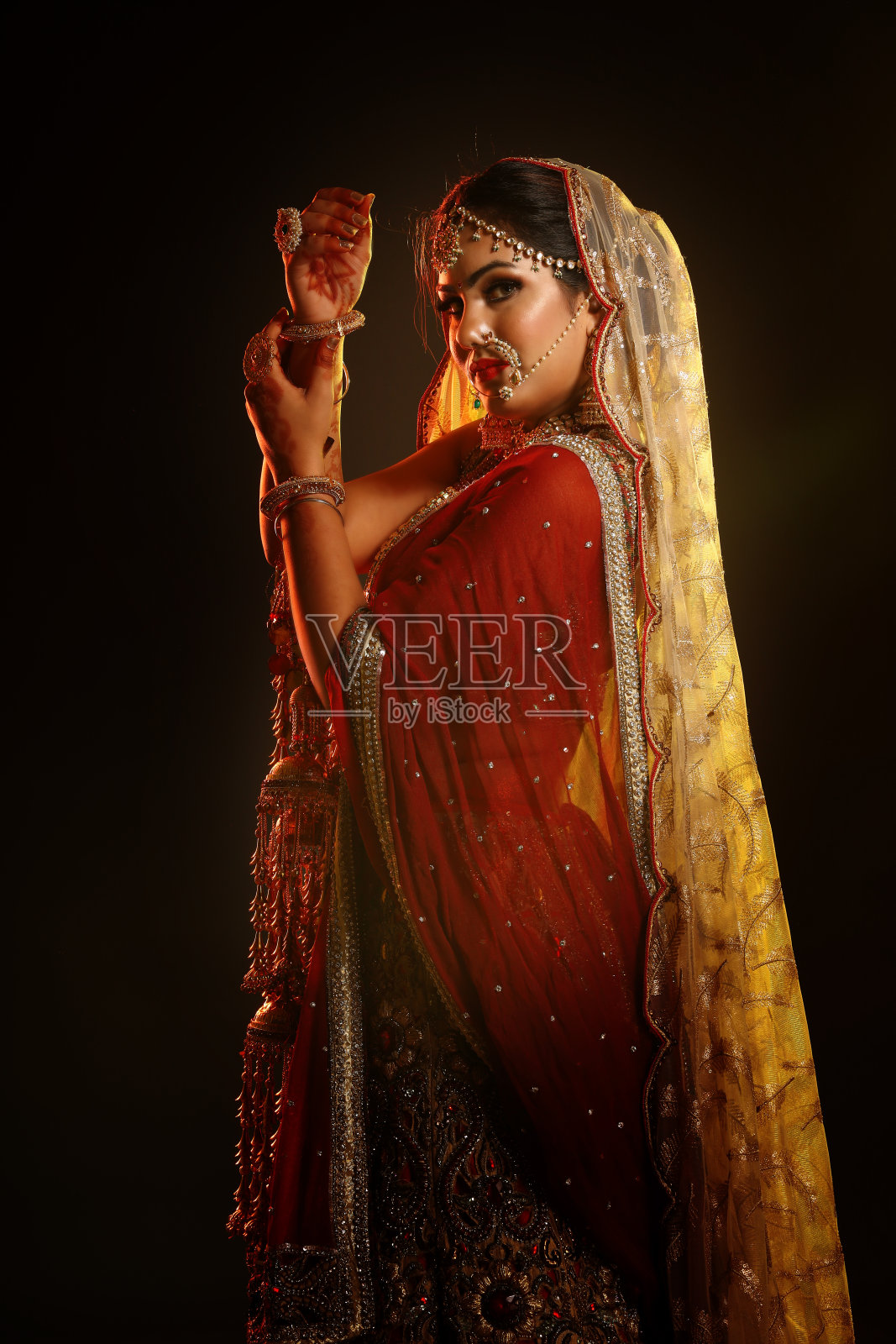 留着发型的印度新娘。为婚礼准备的印度新娘肖像。头发做的。改造完成。化妆。新娘的姿势。印度民族服饰。戏剧性的灯光效果为婚礼和传统仪式。照片摄影图片