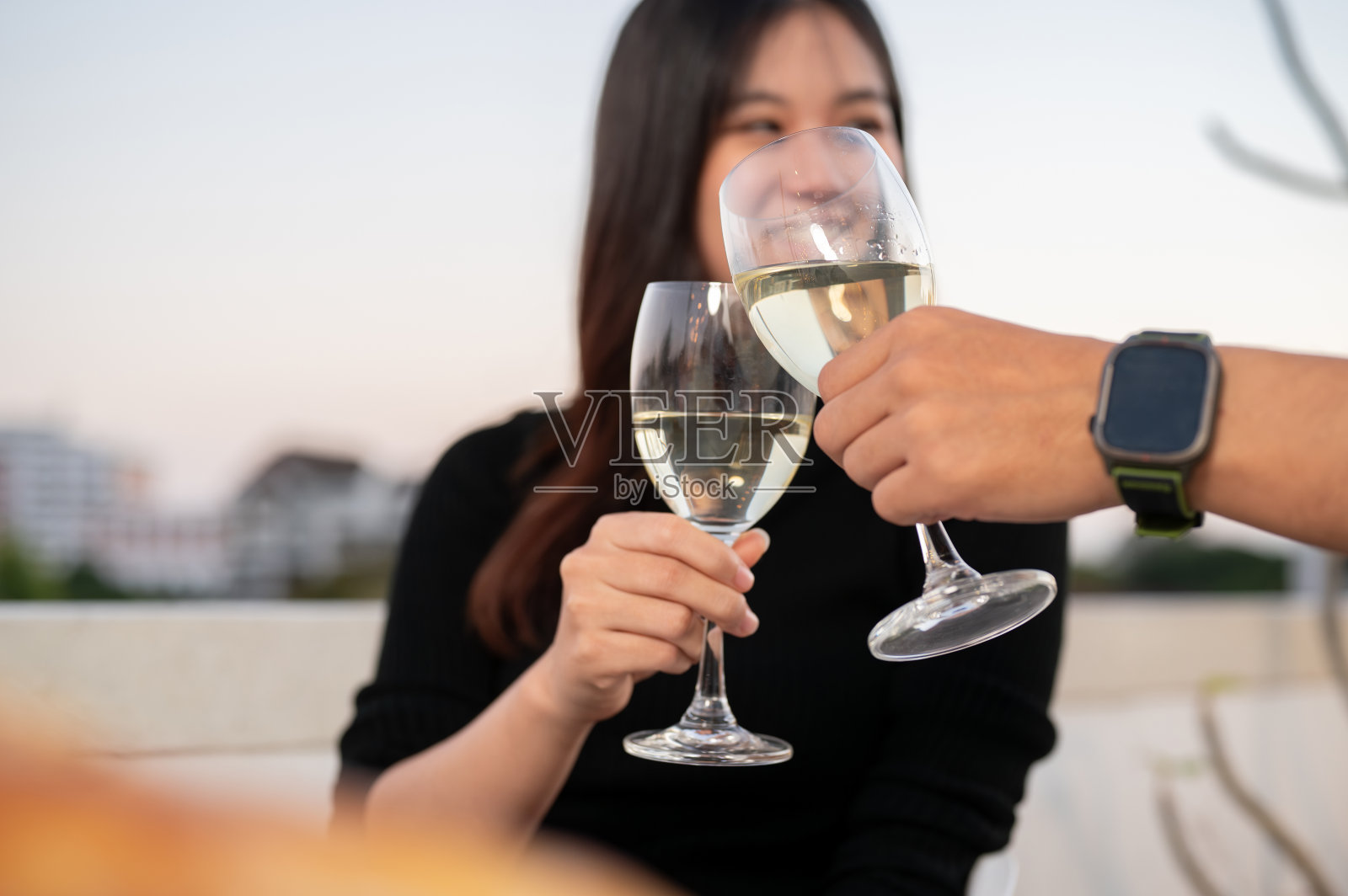 一个漂亮的女人和她的男朋友在屋顶酒吧喝香槟，共度约会之夜。照片摄影图片