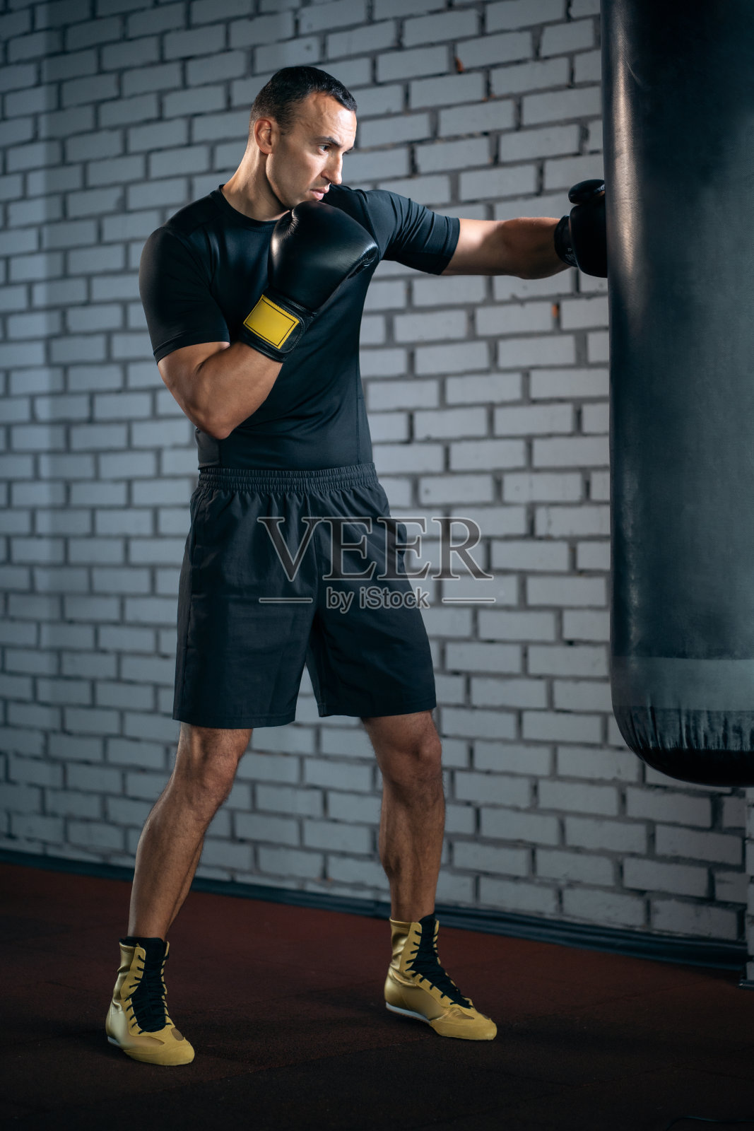 竞技运动员拳击手用沙袋训练或在健身房锻炼照片摄影图片