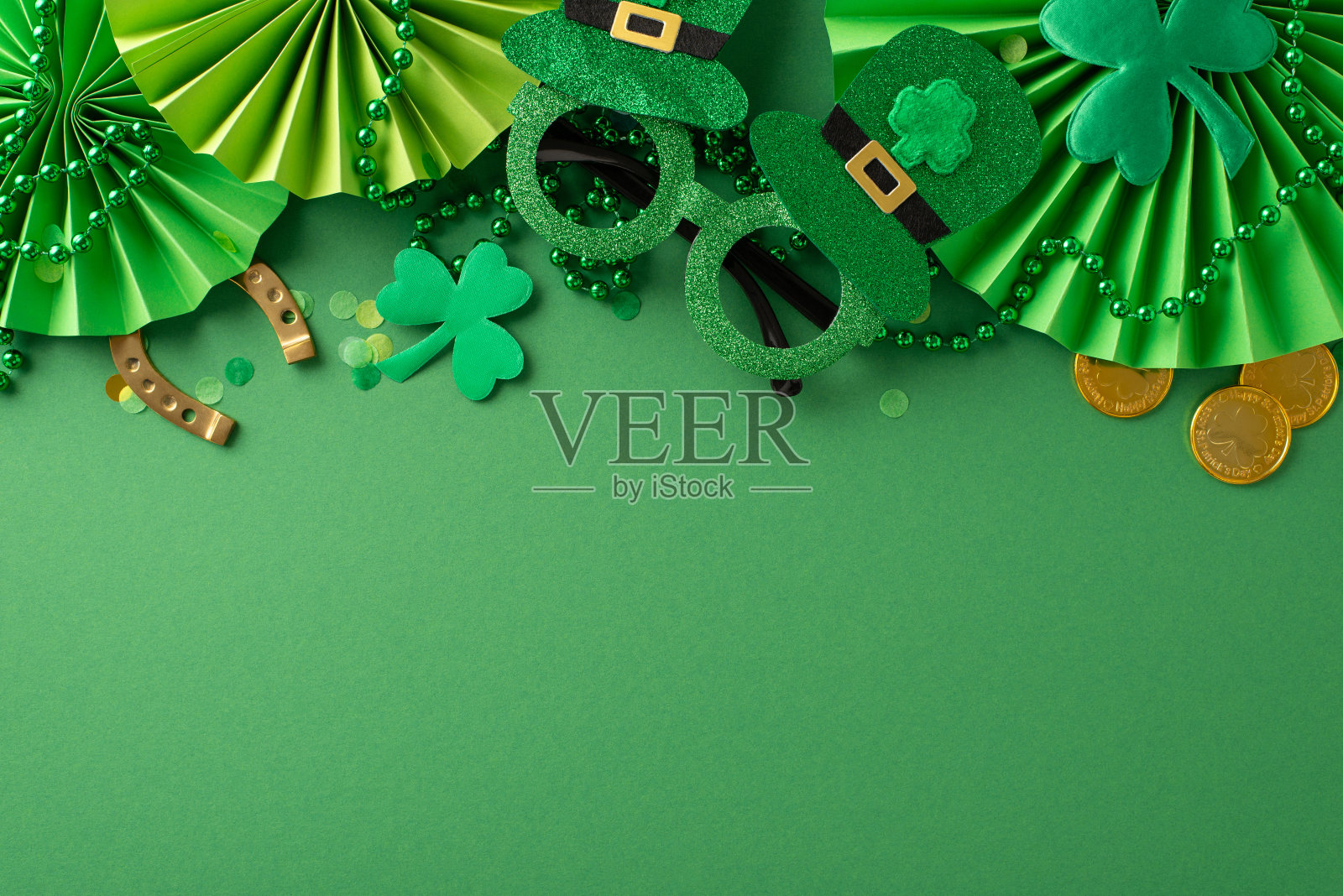 捕捉圣帕特里克节的精髓，俯瞰平面，具有标志性元素:俏皮的派对眼镜，金币，兴奋的粉丝，三叶草，绿色帆布上的五彩纸屑。在露天地方做广告照片摄影图片