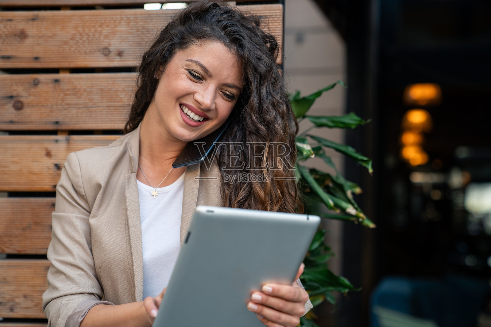 成功的女性经理在户外使用手机和数码平板电脑处理多项任务照片摄影图片