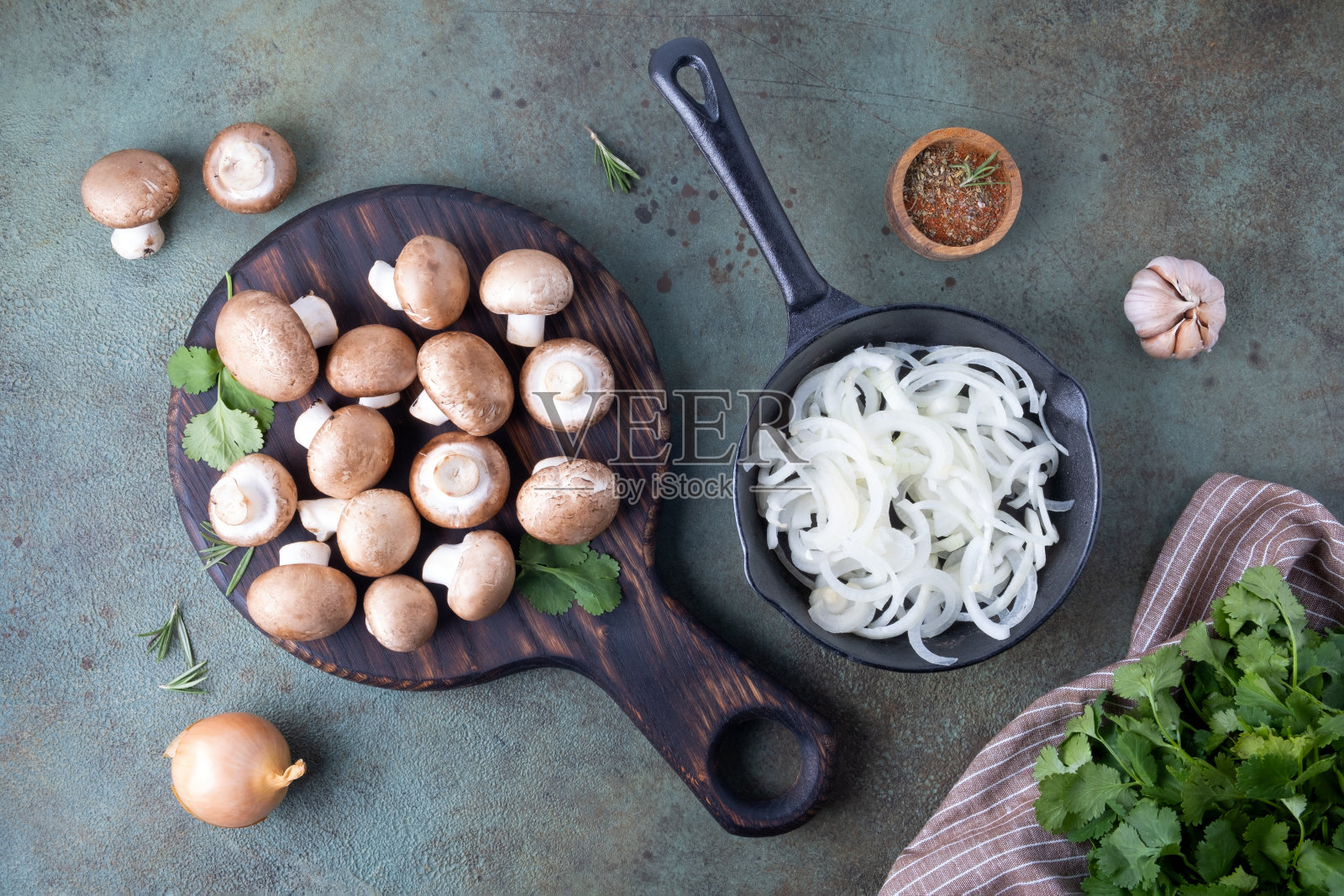 皇家冠军奖杯躺在切菜板上，旁边是一个装满切碎洋葱的煎锅。照片摄影图片