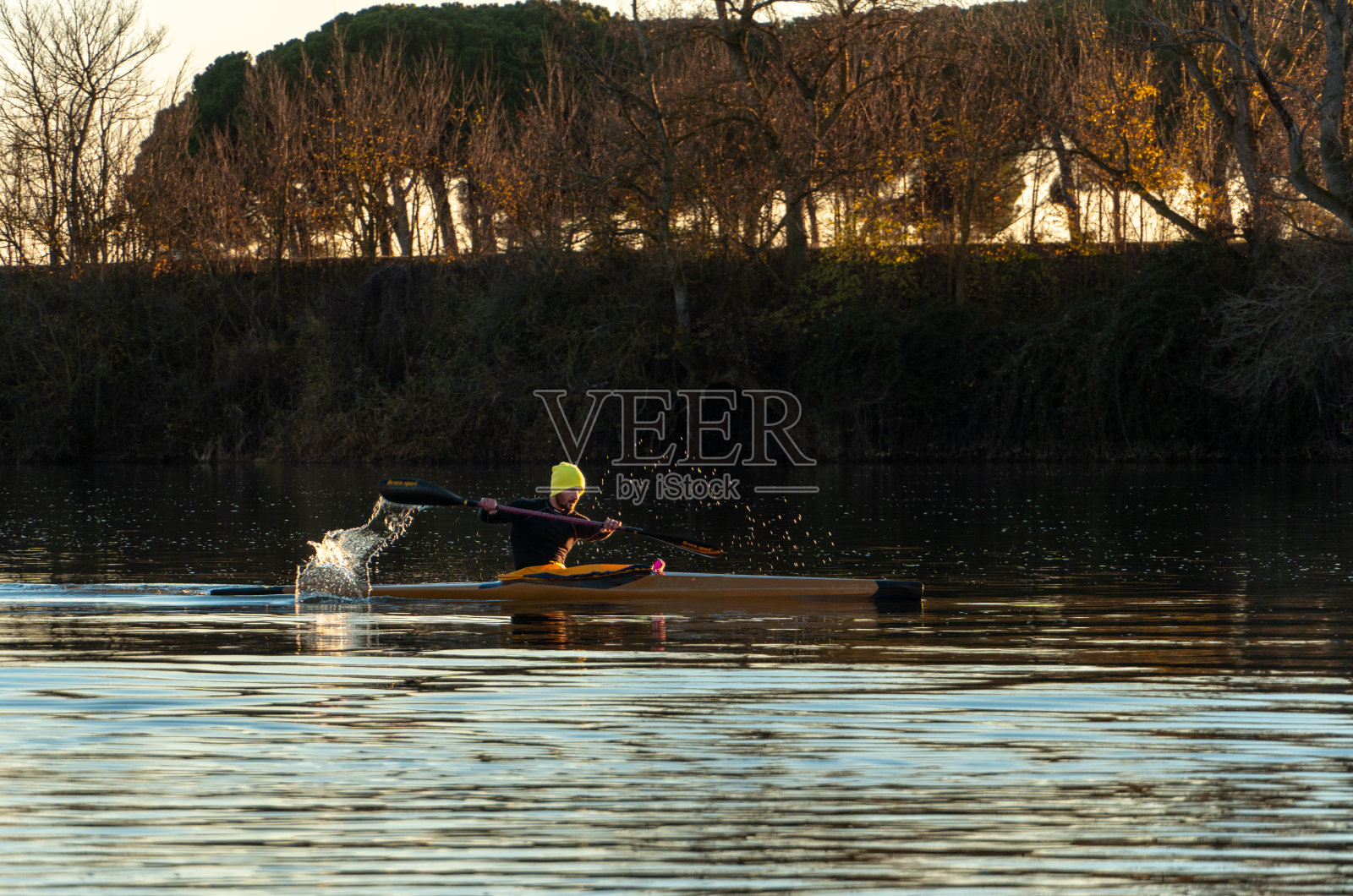 年轻人在日落时分划船训练。照片摄影图片