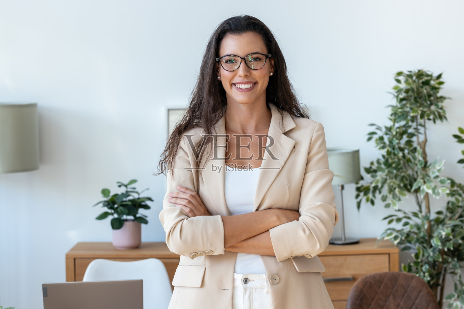 年轻漂亮的女商人站在办公室微笑着看着镜头照片摄影图片
