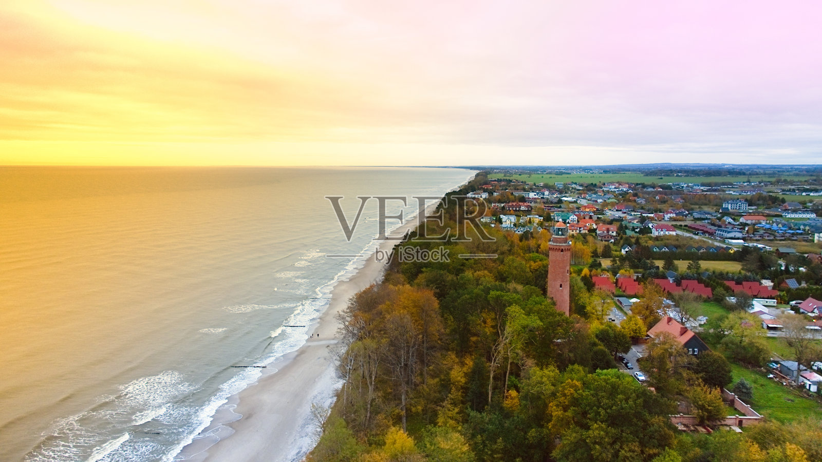 在11月一个多云的日子里，无人机捕捉到Gski灯塔矗立在阴暗的天空中。宁静的大海与温柔的波浪拍打着空旷的海滩，创造了一个宁静的海岸场景，邀请反思和孤独。照片摄影图片