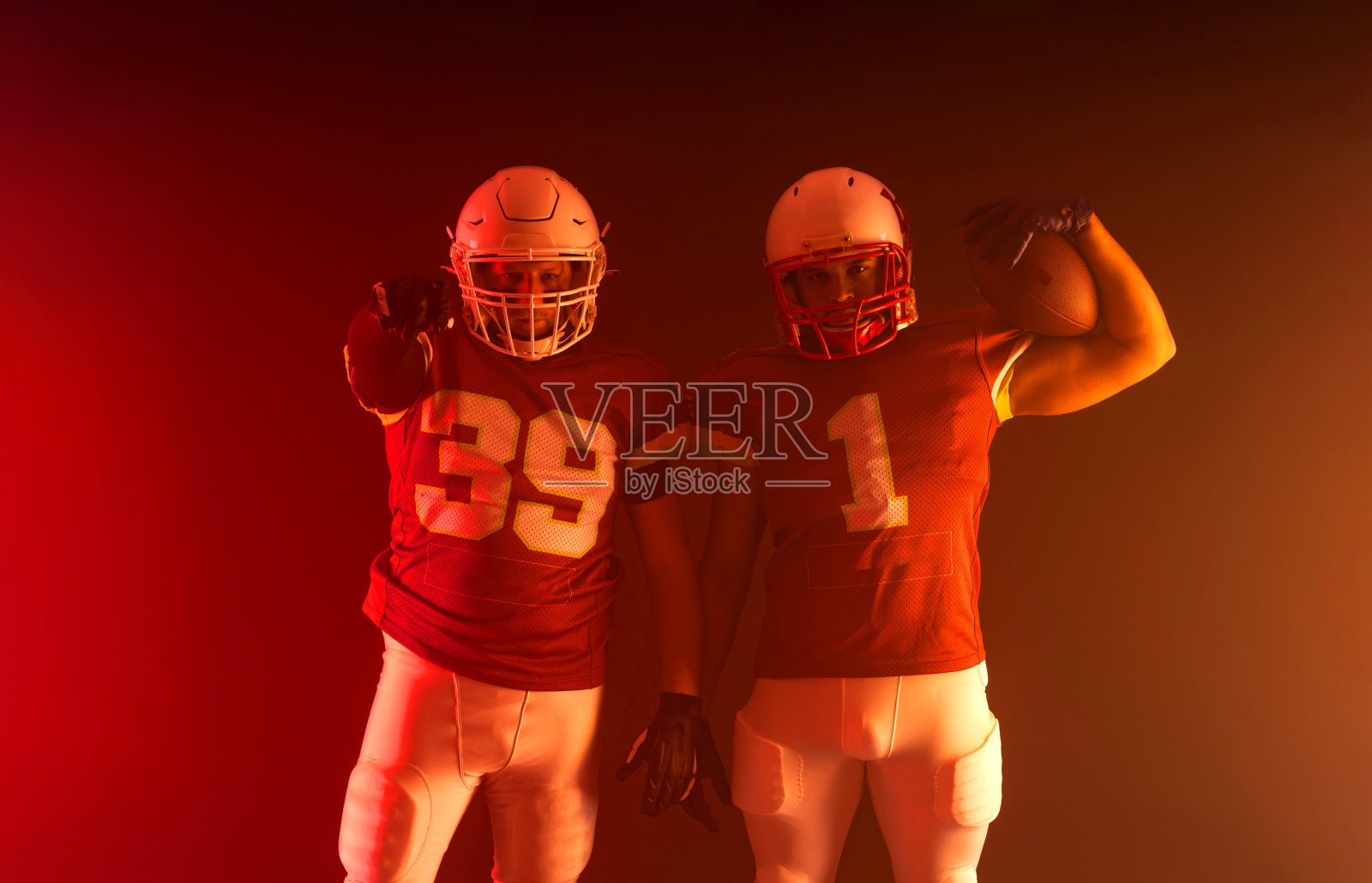 两个美式橄榄球运动员在霓虹灯下。带有复制空间的博彩公司广告模板。投注广告模型。照片摄影图片