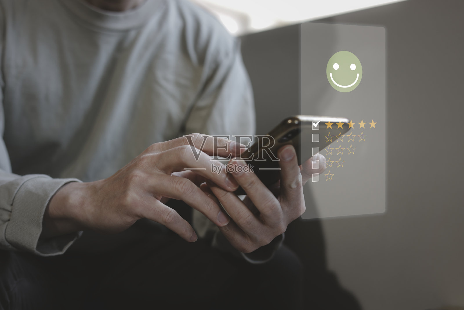 客户服务评估和反馈评级。顾客评论概念，男人用手机选择快乐的笑脸照片摄影图片