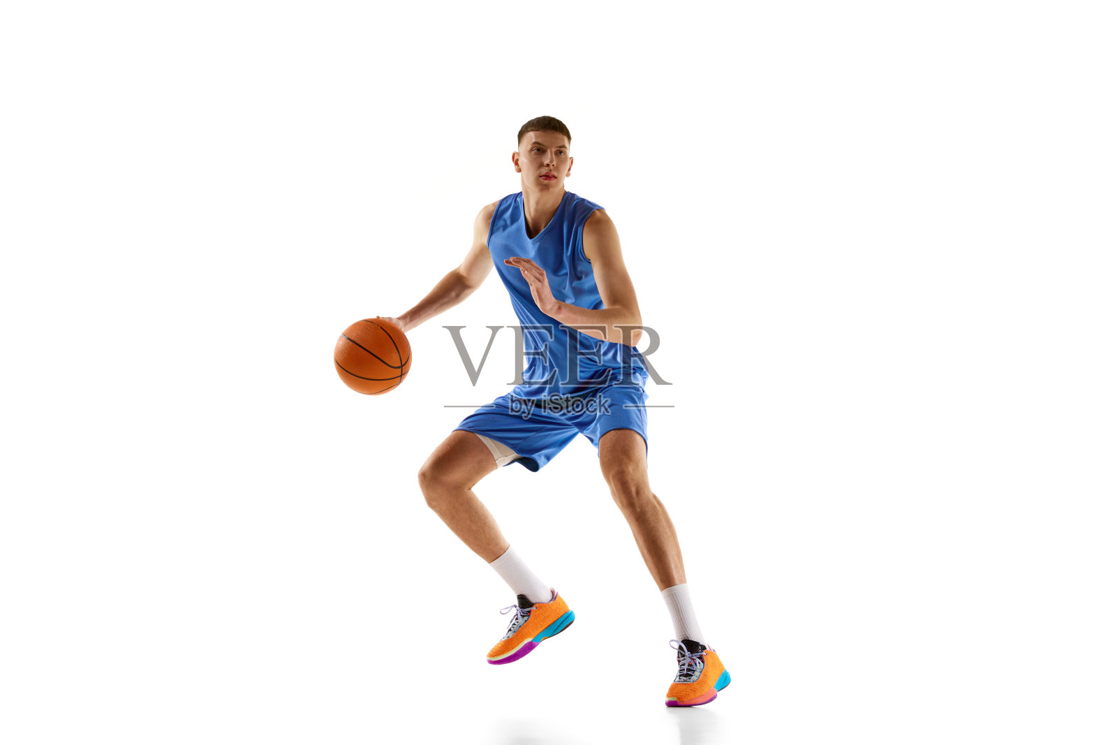 年轻男子在蓝色制服的动态图像，篮球运动员在比赛中运动，运球孤立在白色背景。体育的概念照片摄影图片