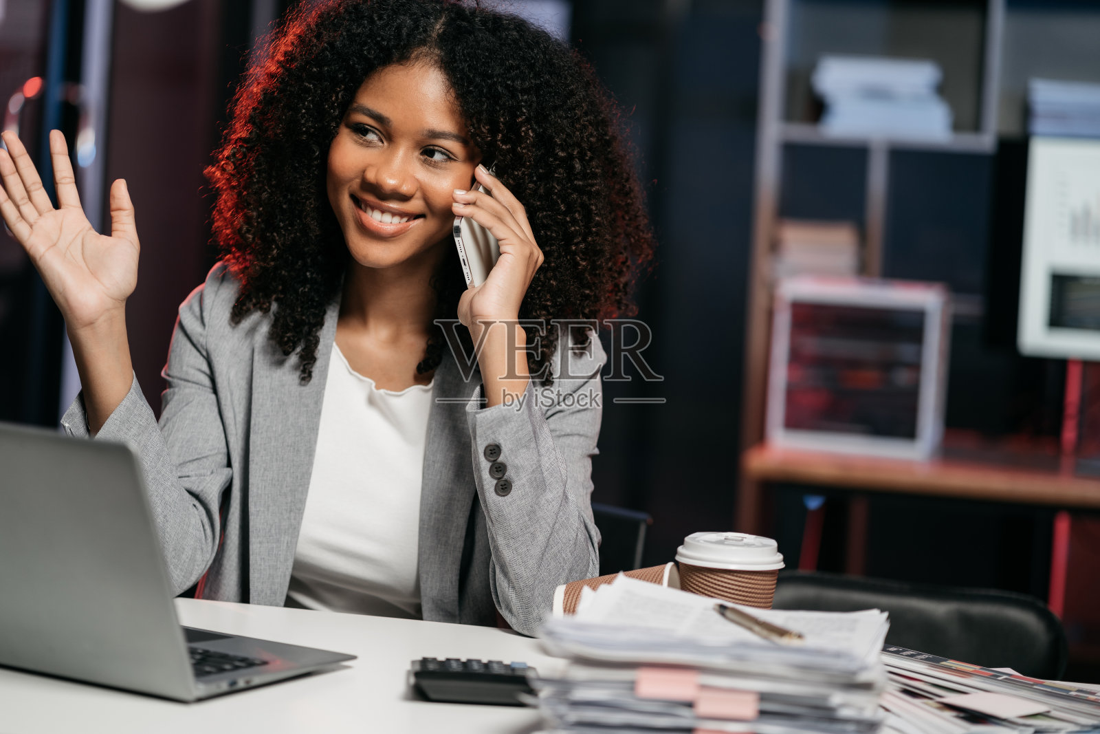 商务女性讲手机，用笔记本电脑工作，网上做生意。照片摄影图片