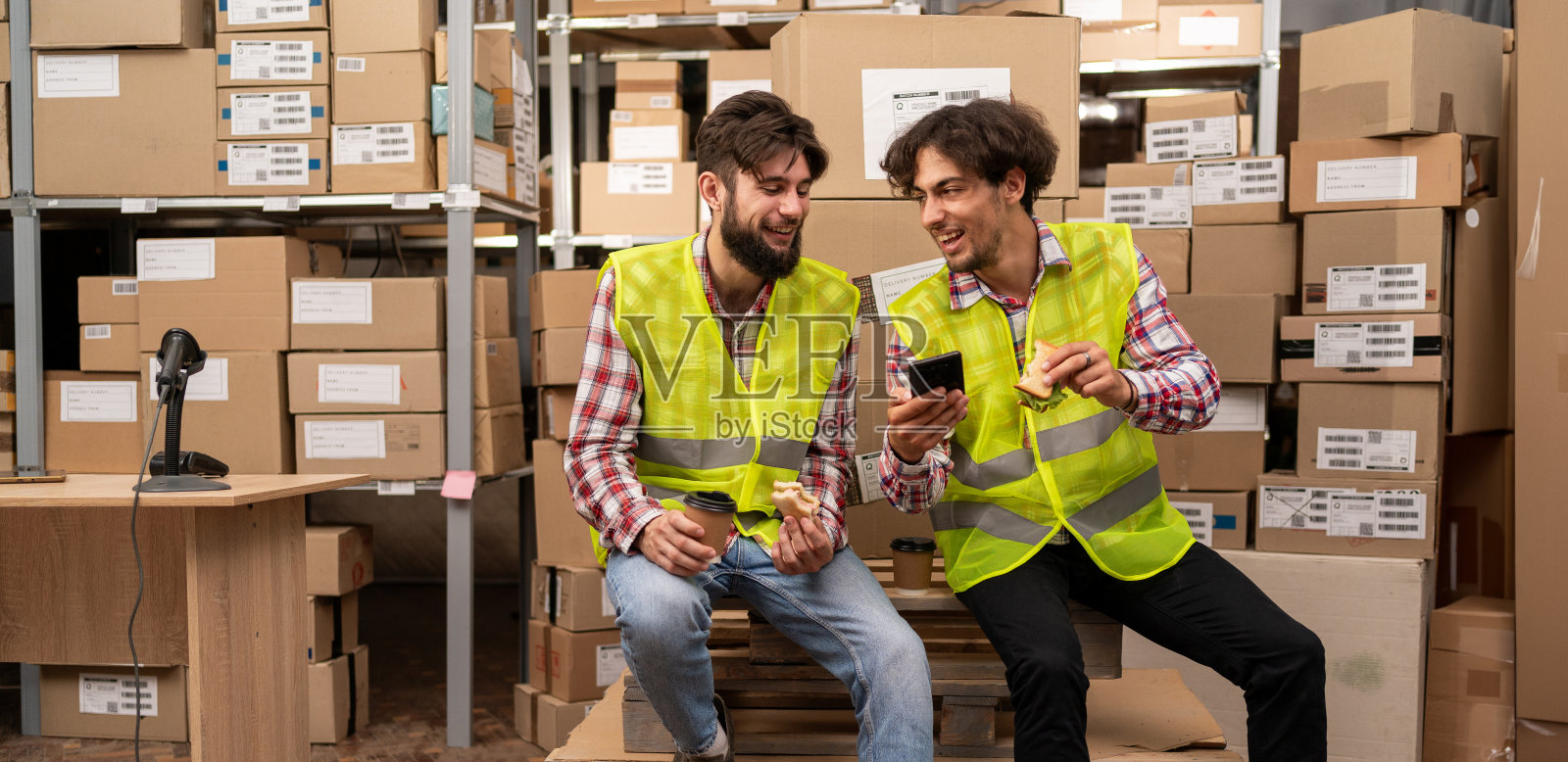 两个男工人午休时在仓库聊天照片摄影图片