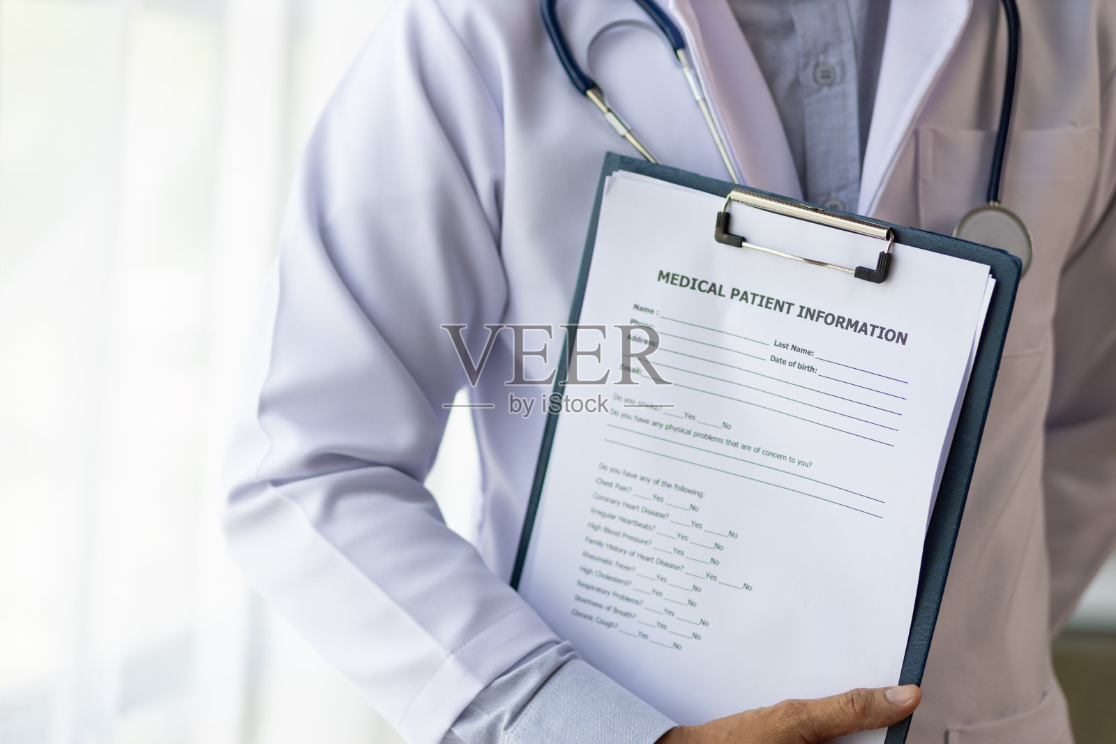 在医院的检查室里，医生拿着健康检查文件。照片摄影图片