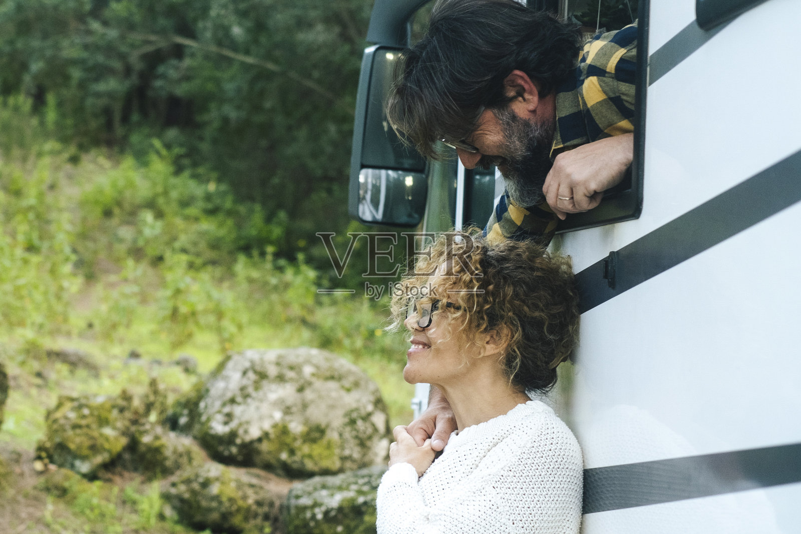 幸福的成年夫妇男女一起享受户外休闲活动与露营车在绿色户外山风景停车场。另类的旅行生活方式和游牧民族的爱情照片摄影图片