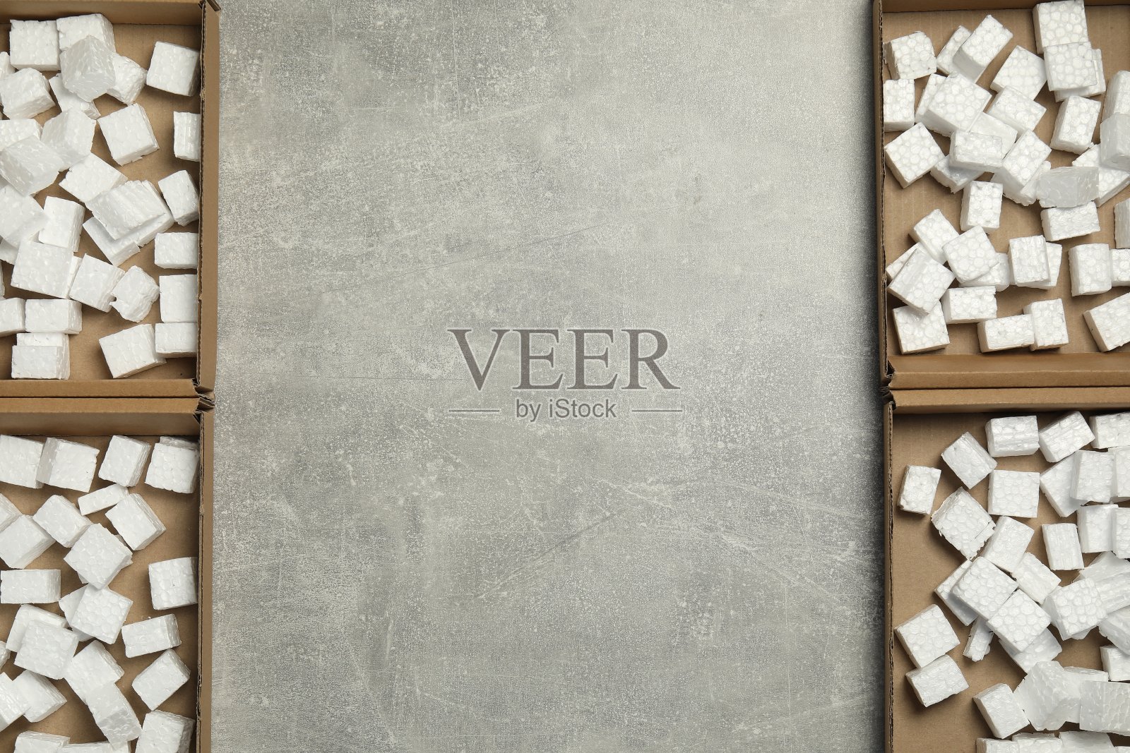 灰色纹理的背景上，许多装有聚苯乙烯泡沫的开着的纸板箱，平铺着。文本空间照片摄影图片