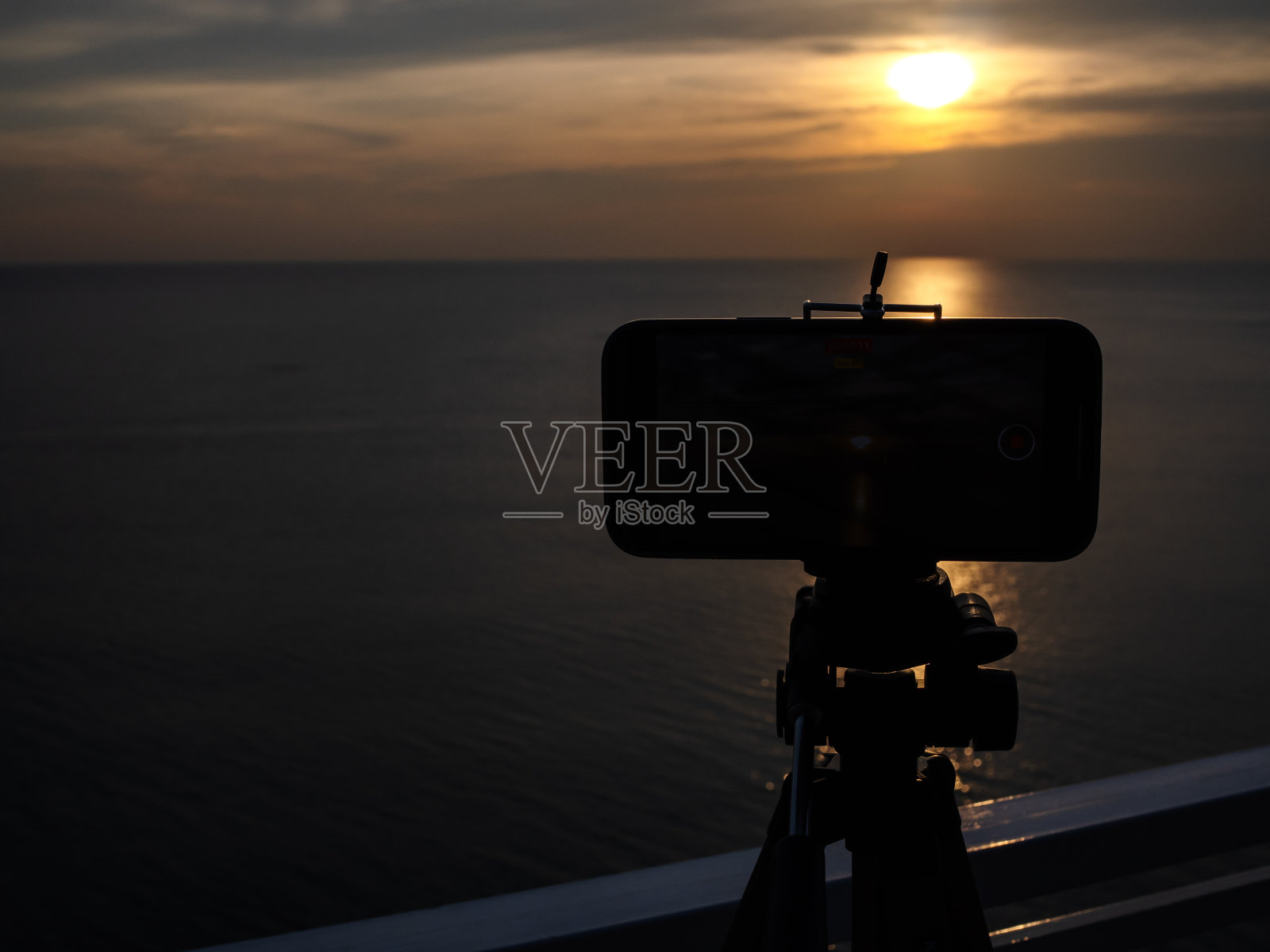 手机和拍摄夕阳的气氛照片摄影图片