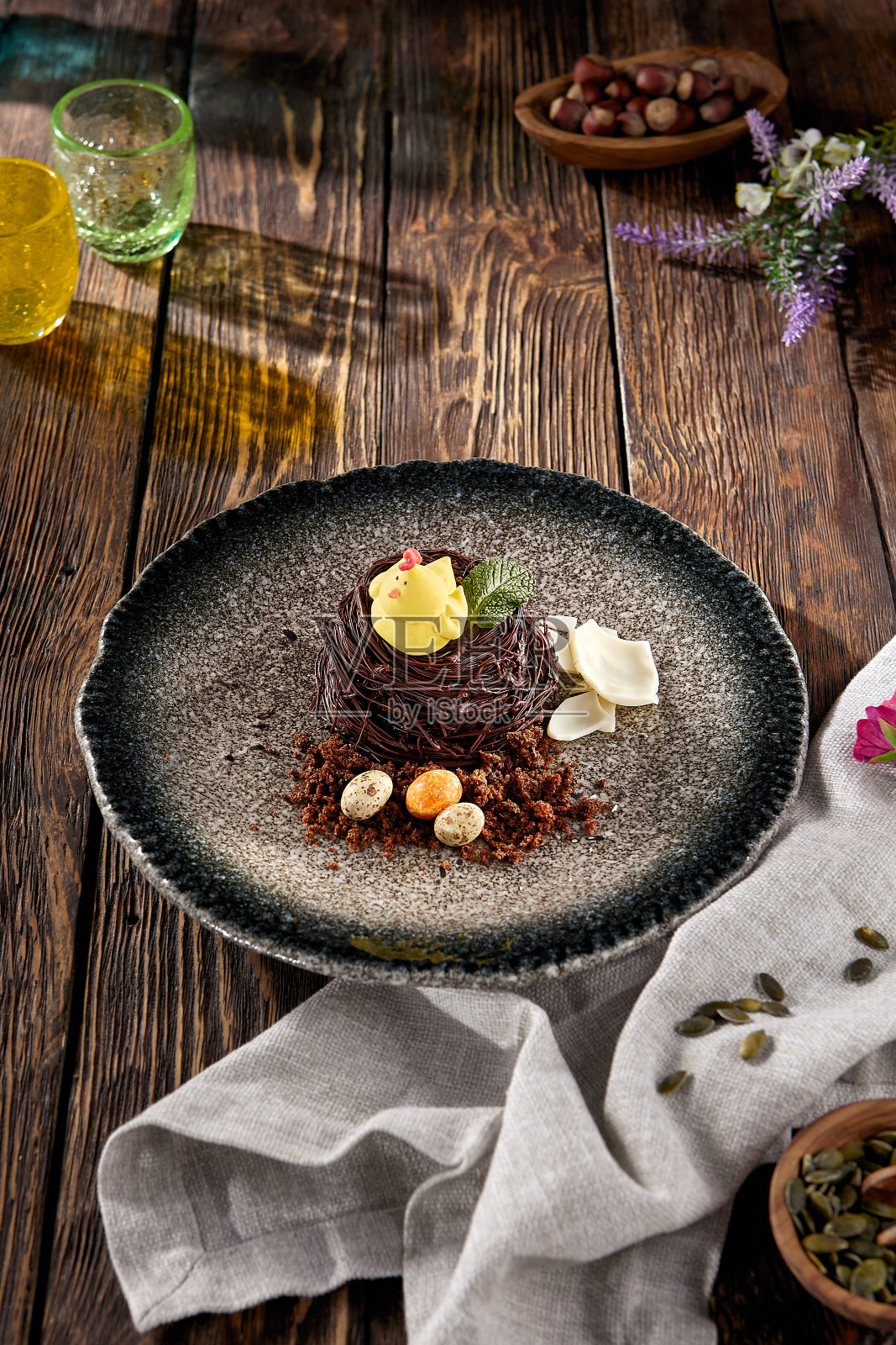 鸡窝形酥皮配小鸡，装在有斑点的盘子里照片摄影图片