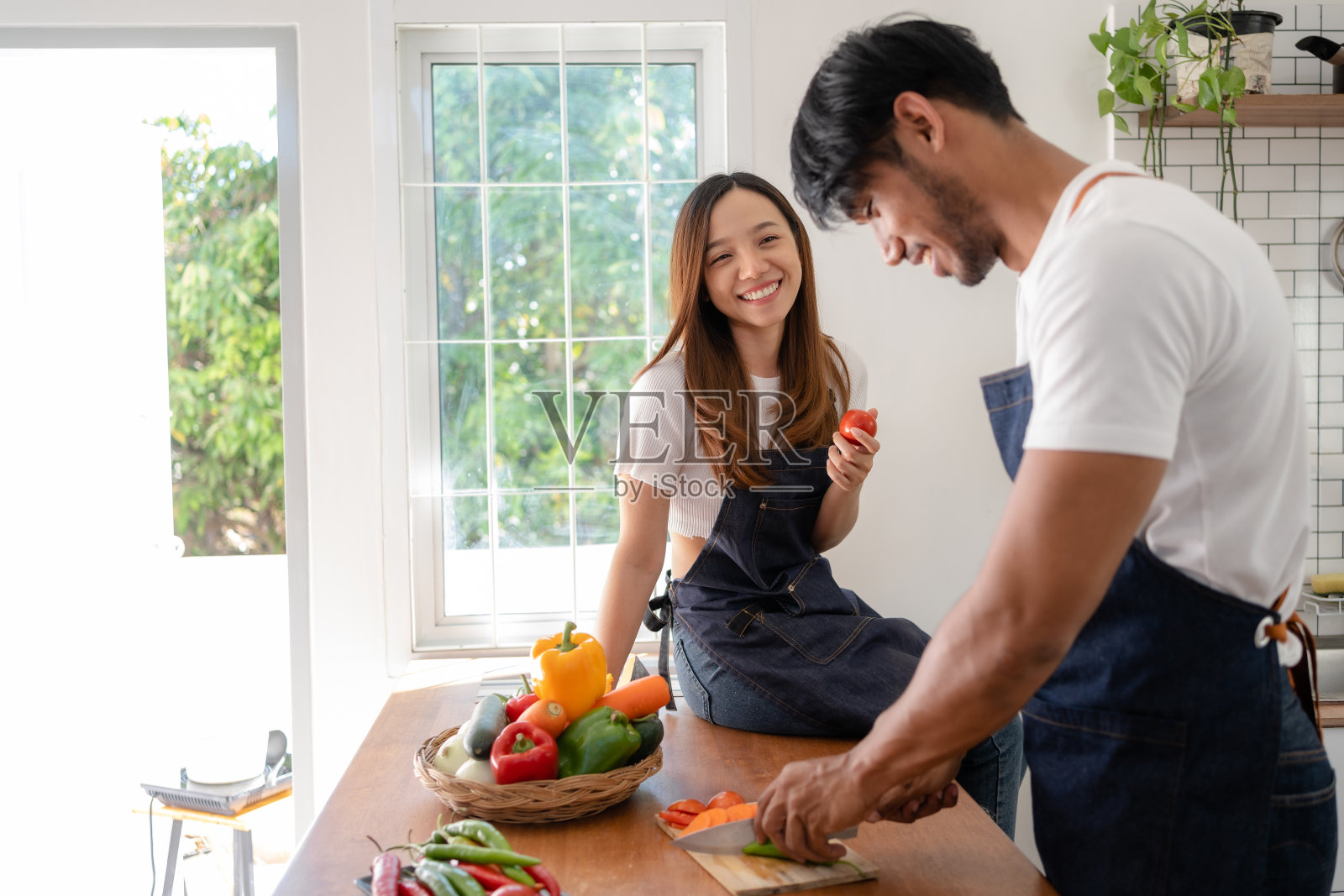 快乐的亚洲夫妇在厨房准备食物做早餐祝你们烹饪愉快。照片摄影图片