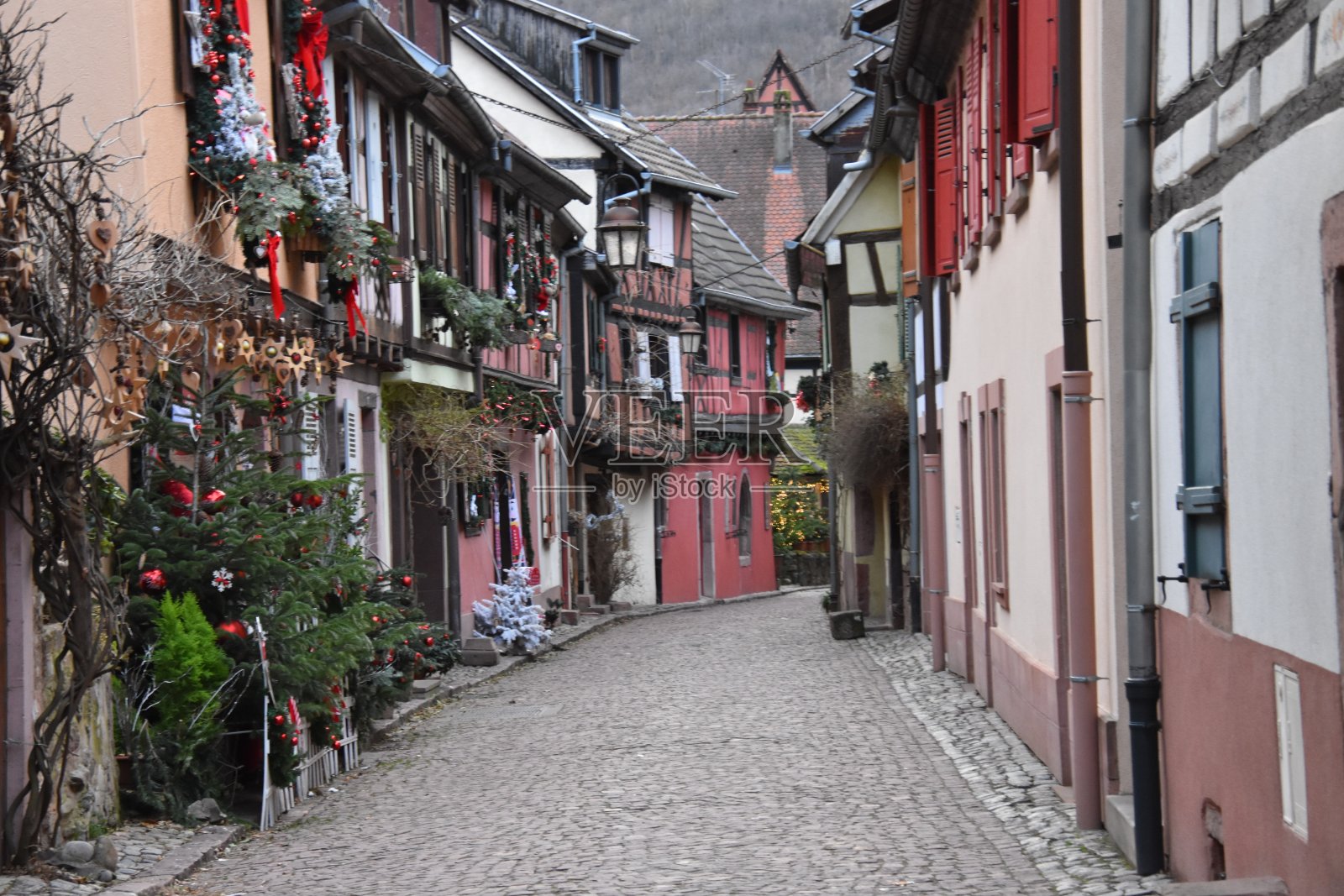 在法国阿尔萨斯的凯瑟斯堡，一条有彩色房屋和人行道的街道照片摄影图片
