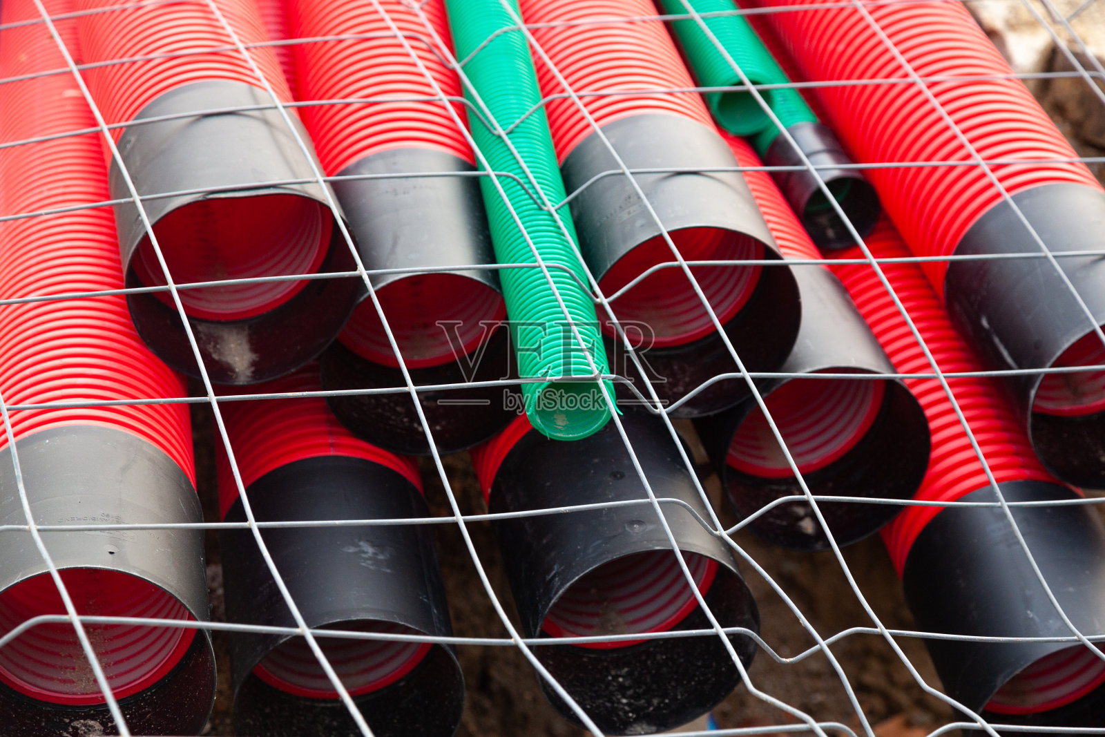 红色塑料波纹管外包有钢网。照片摄影图片