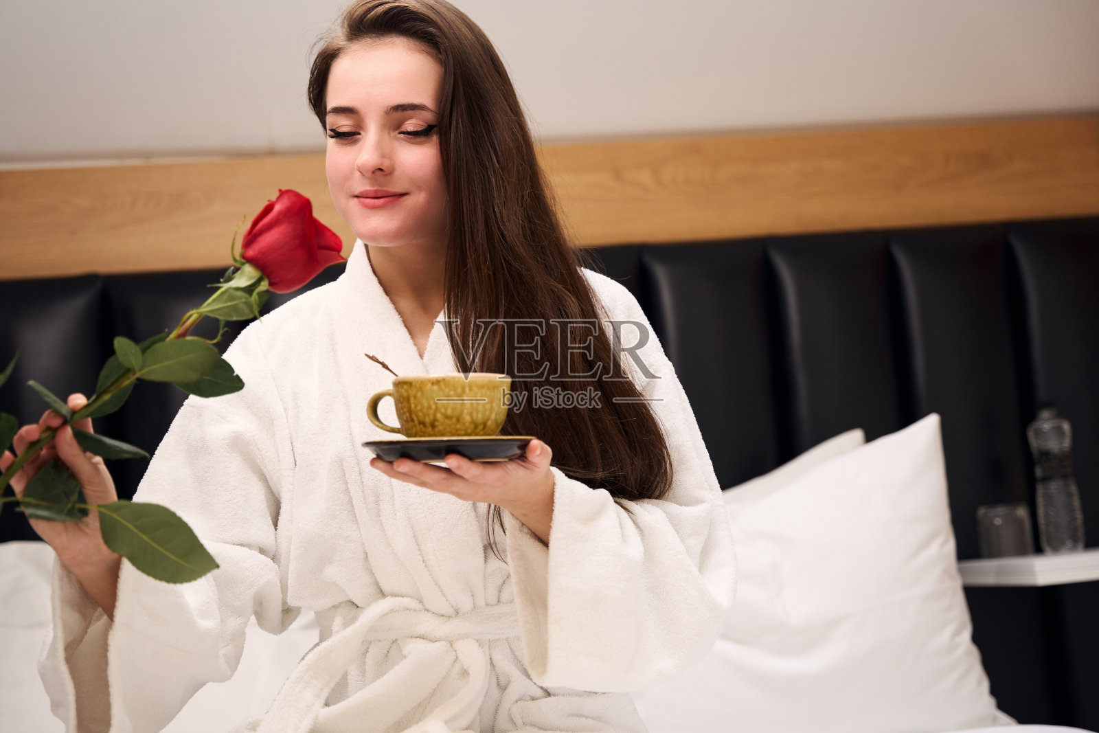 美丽的女人在现代卧室里享用浪漫的早餐照片摄影图片