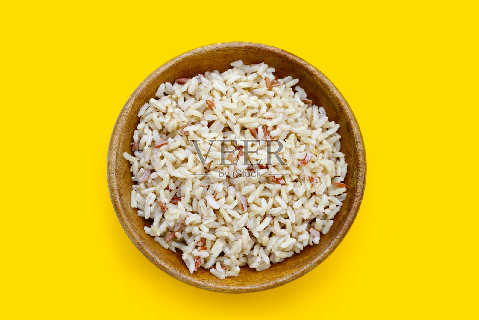 黄底木碗煮糙米。照片摄影图片