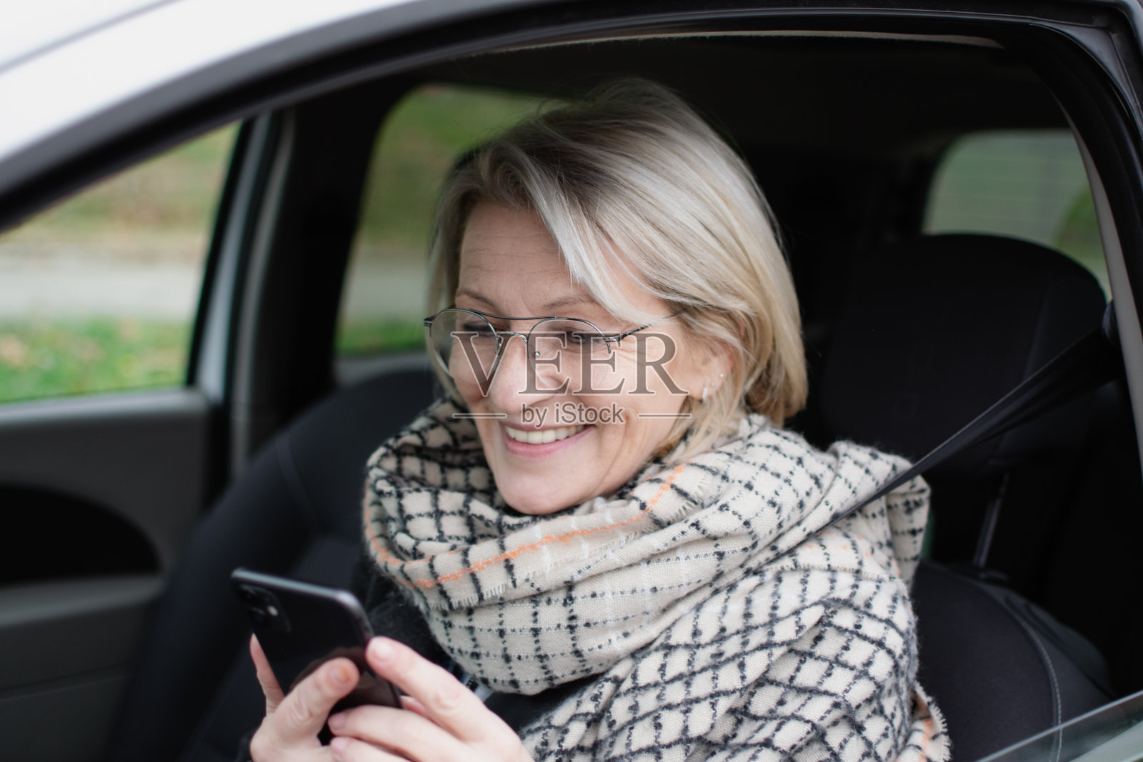 成熟的金发女人坐在车里照片摄影图片