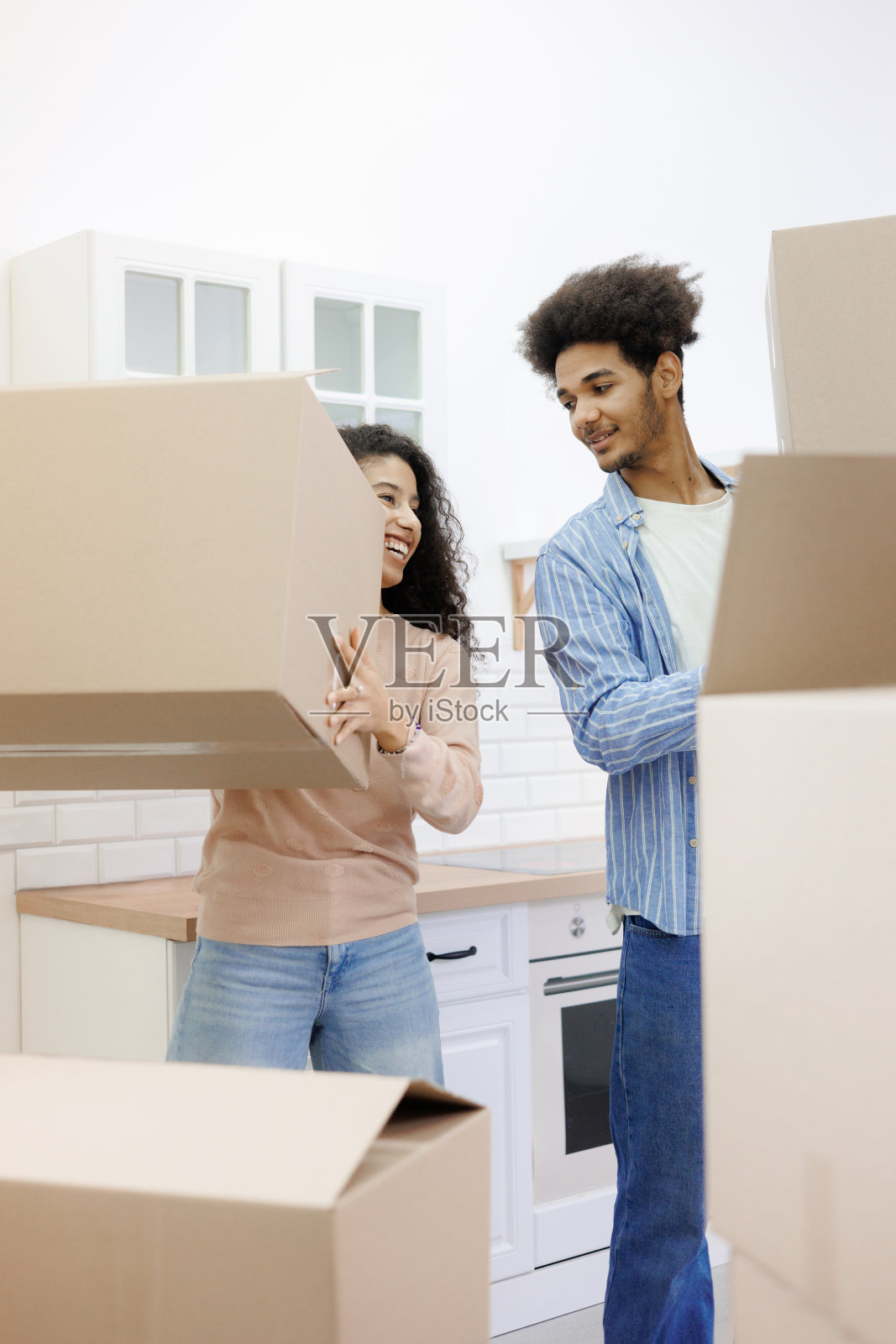 快乐的年轻人搬到新家。购买住宅、抵押或出租。照片摄影图片