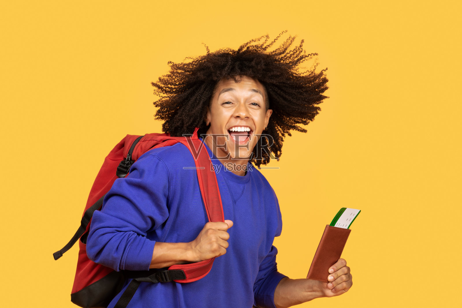 快乐的旅行。兴奋的年轻黑人男子背着背包和护照照片摄影图片