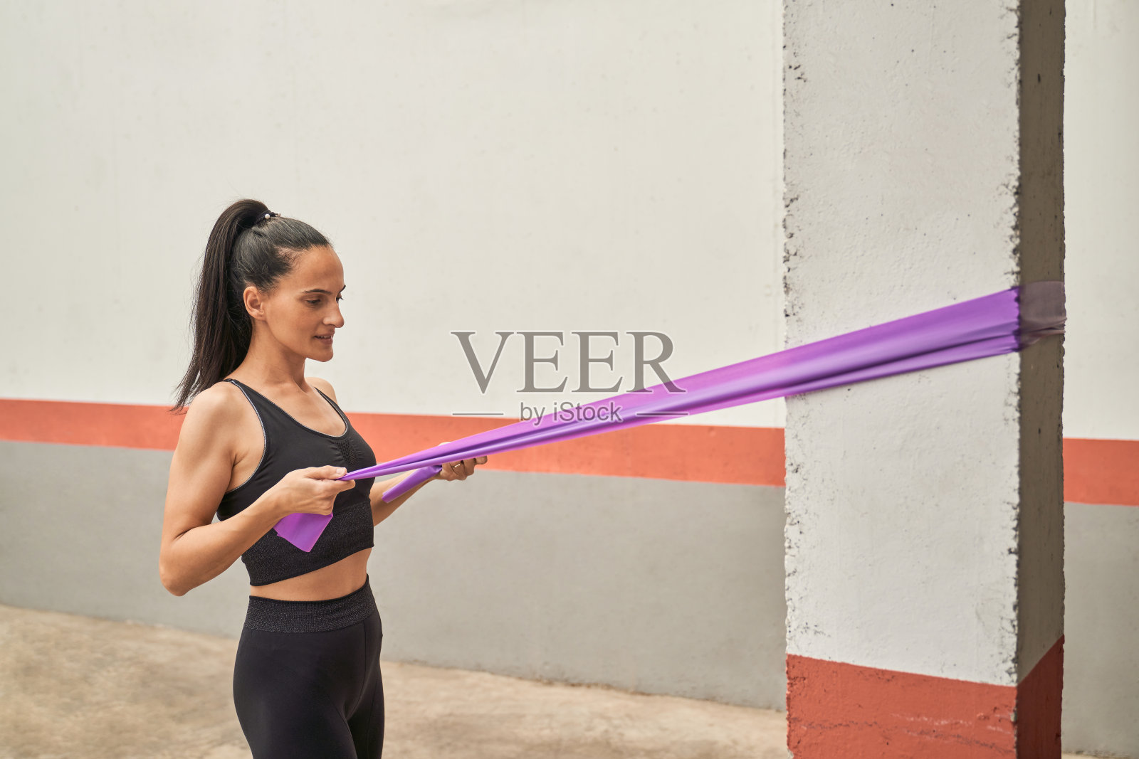 女运动员在健身房用橡皮筋锻炼照片摄影图片