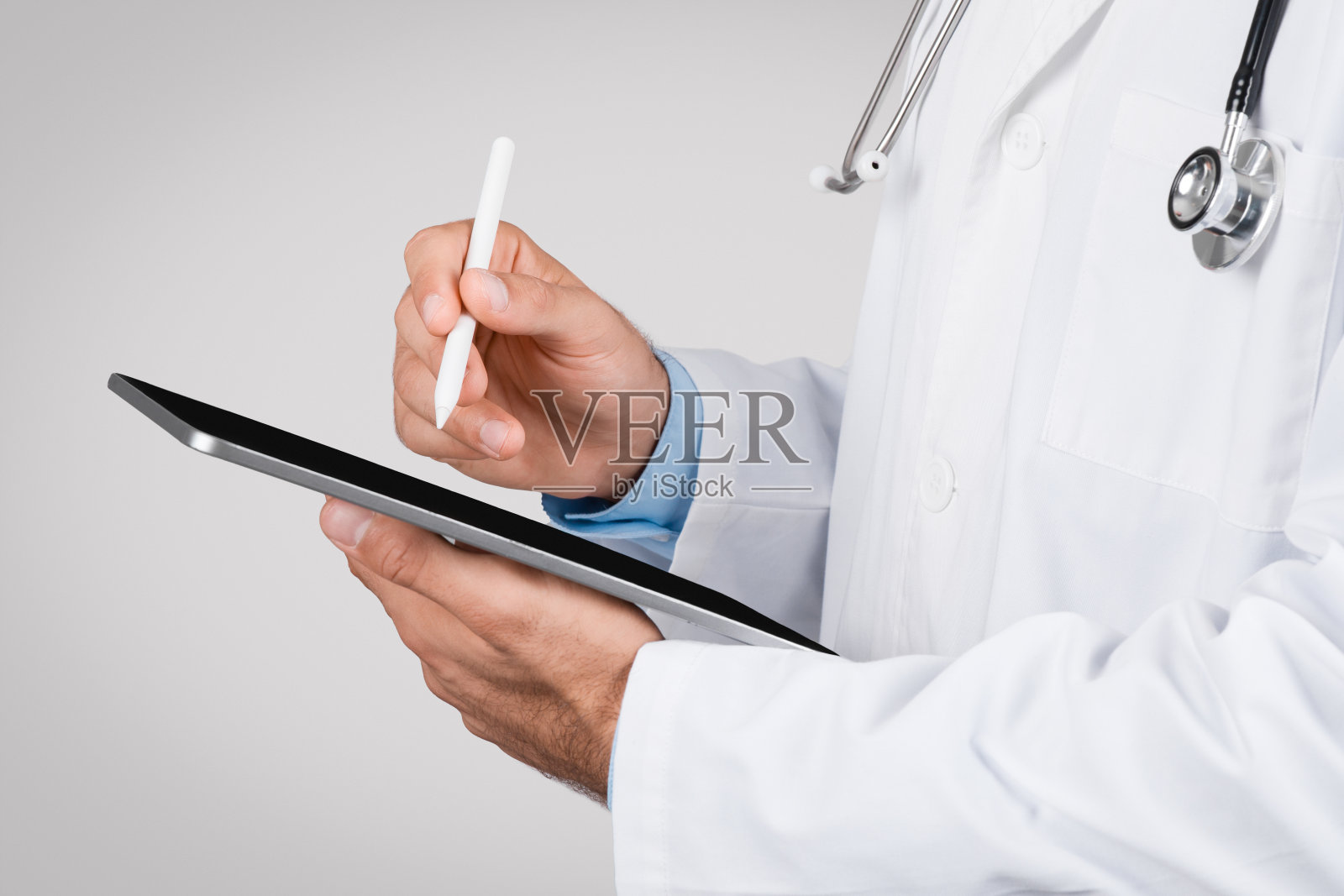 医生使用带触控笔的数字平板电脑，特写照片摄影图片