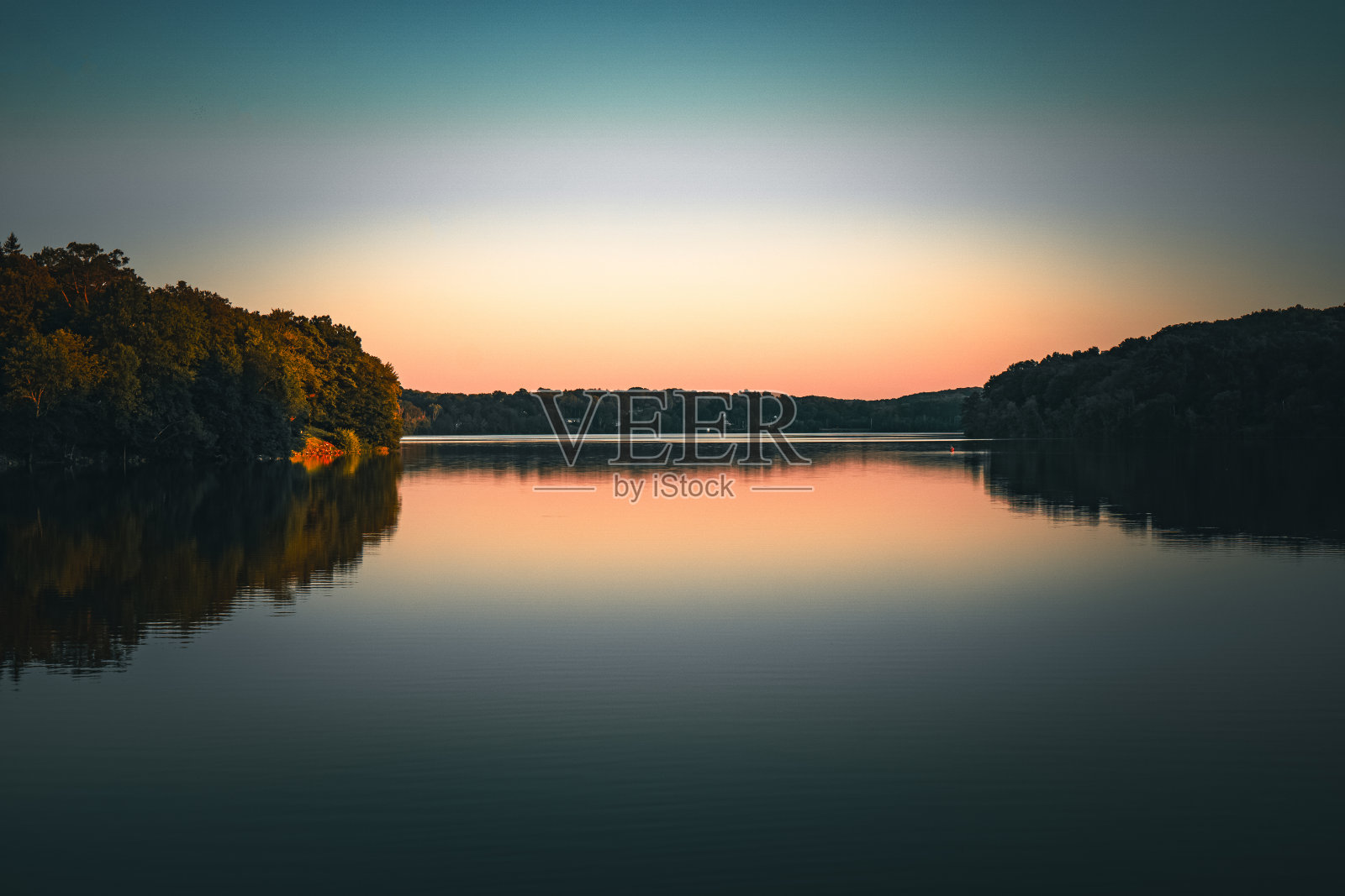 宁静地区的景观被树木覆盖，倒影在平静的水中照片摄影图片