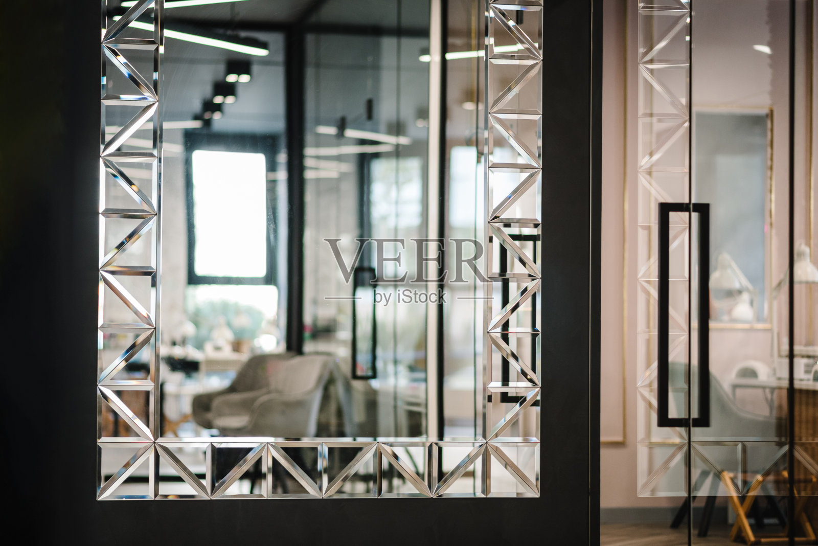 房间里有一面大镜子和一张反射扶手椅。透明的玻璃门通向明亮的客厅。现代的室内细节。特写镜头。照片摄影图片