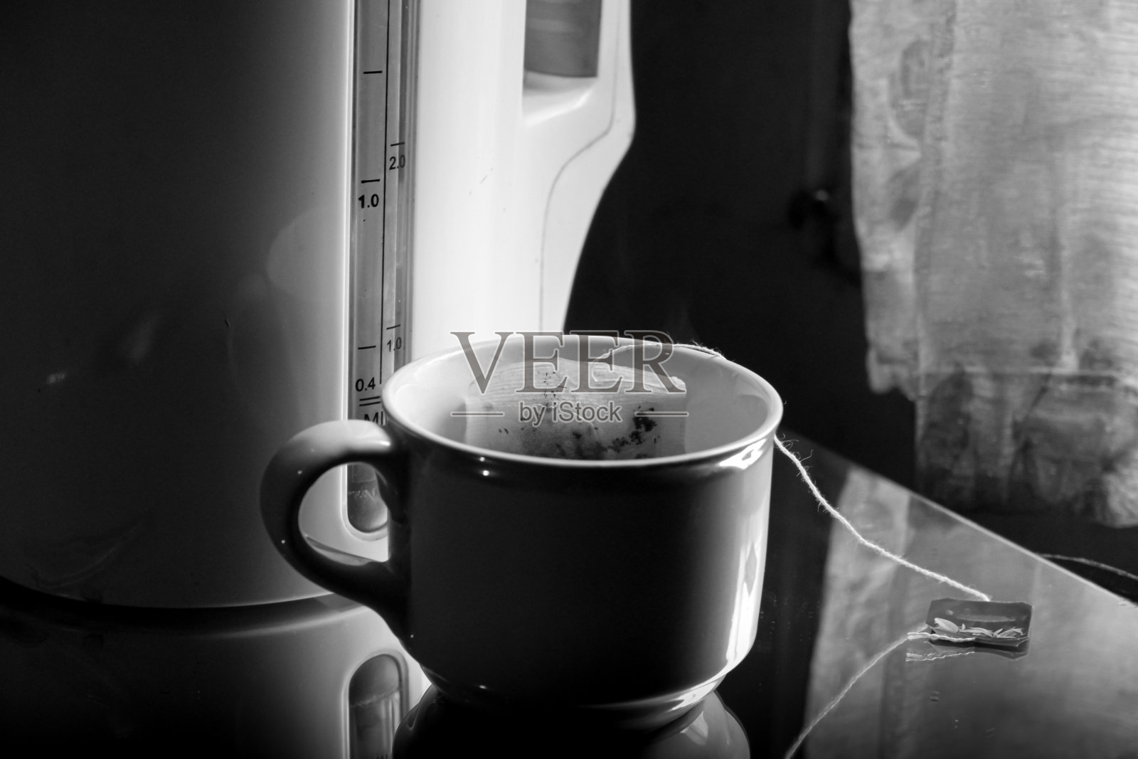 桌子上的一杯茶，映衬着窗外的光线照片摄影图片