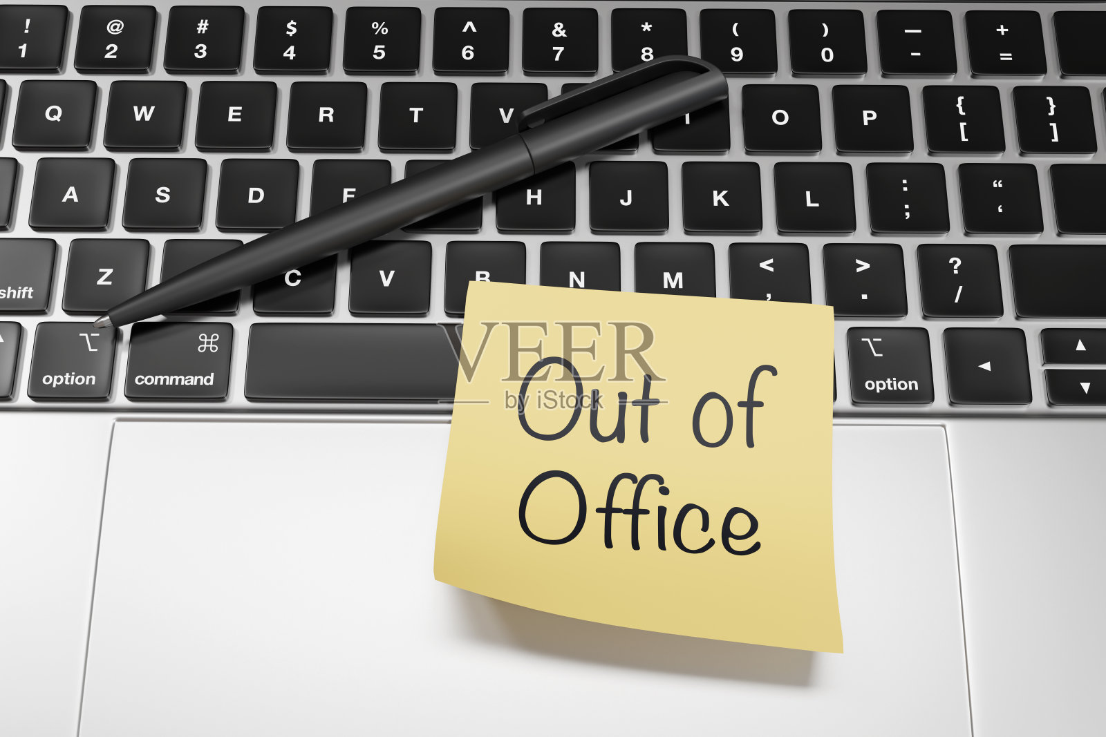 黄色便签上写着“不在办公室”的信息，贴在银色笔记本电脑上。说明员工年假及公众假期的概念照片摄影图片