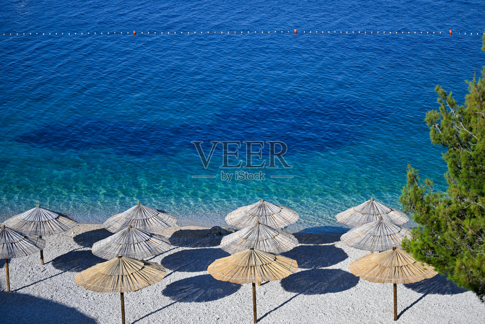 沙滩上的草伞照片摄影图片