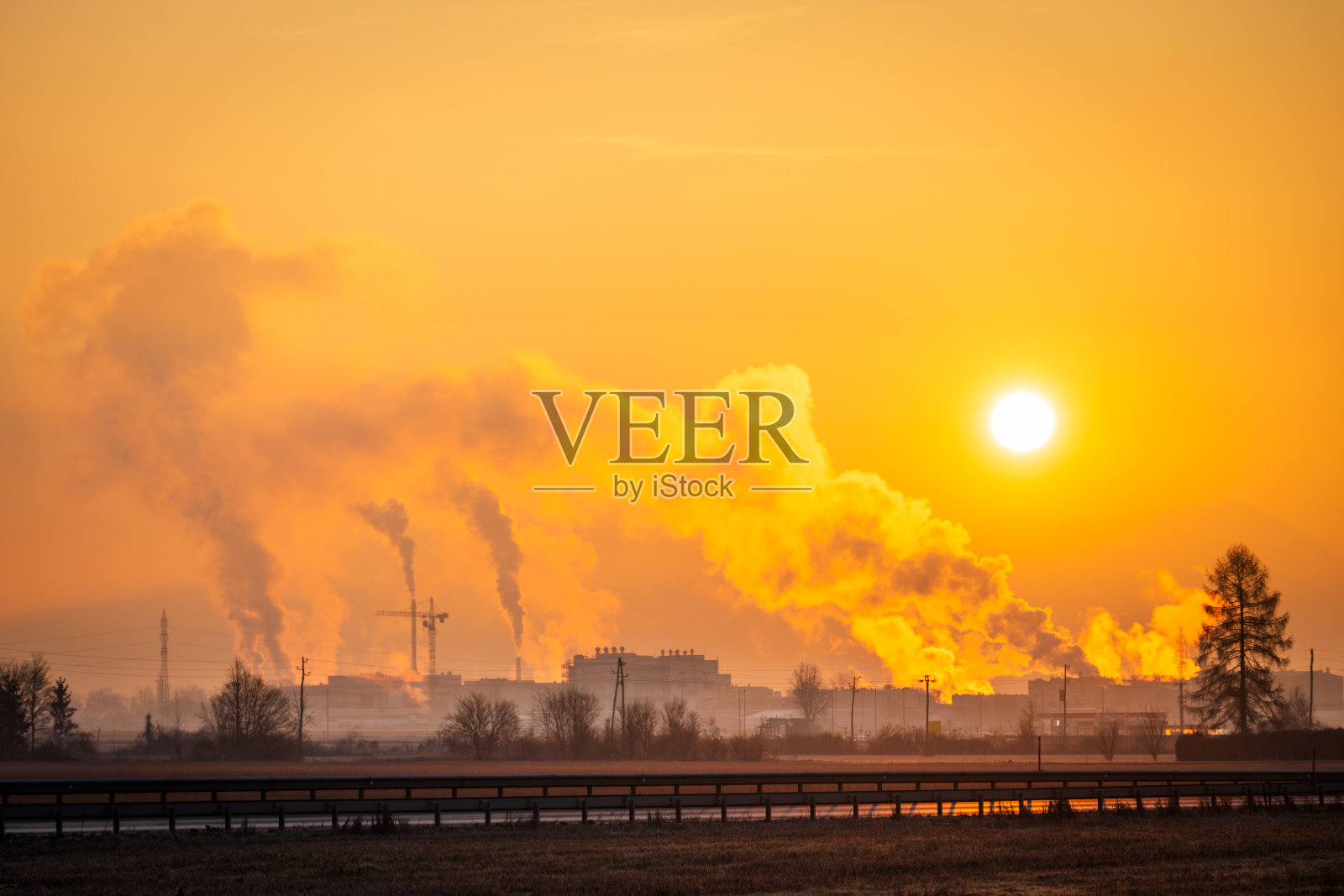 朝阳下，工厂的晨烟袅袅升起照片摄影图片