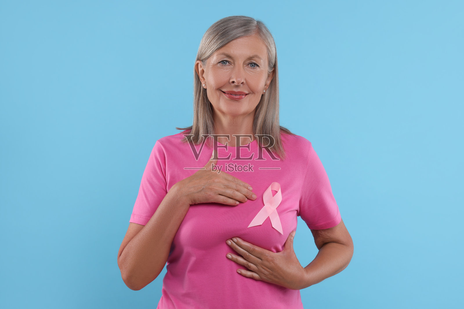 浅蓝色背景粉丝带的资深女性。乳腺癌意识照片摄影图片