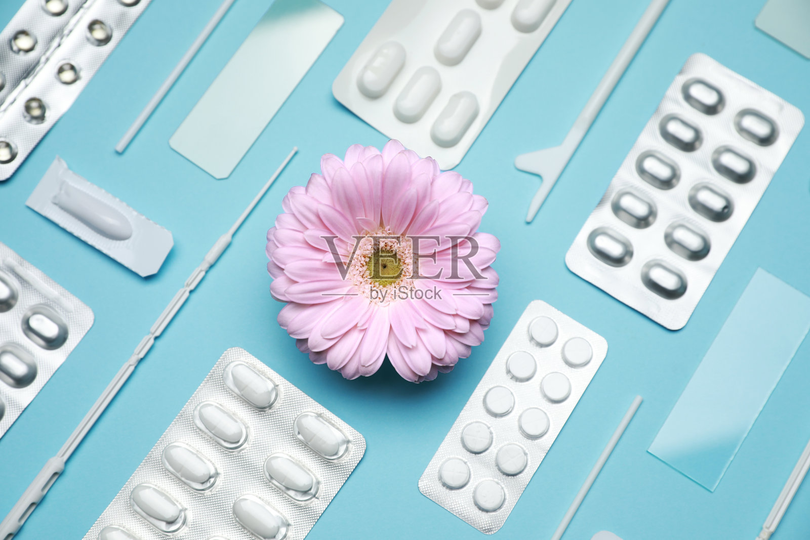 许多妇科药丸、工具和非洲菊花在浅蓝色的背景上，平躺着照片摄影图片