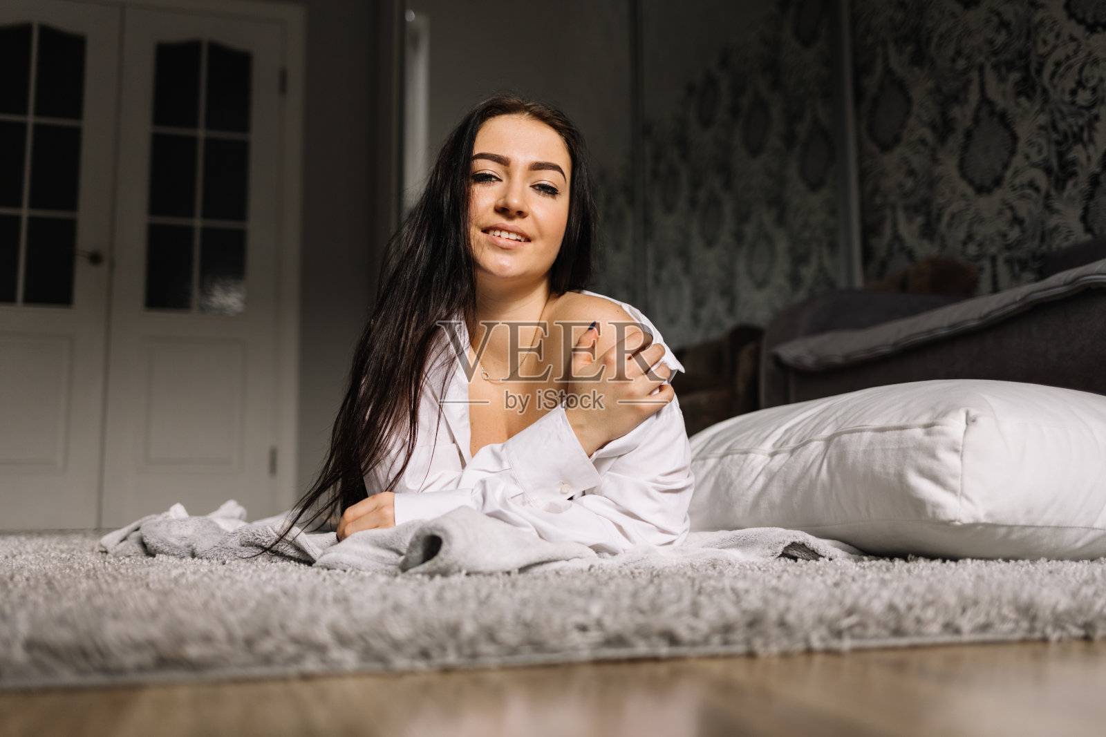 漂亮的黑发女人坐在床上醒来照片摄影图片