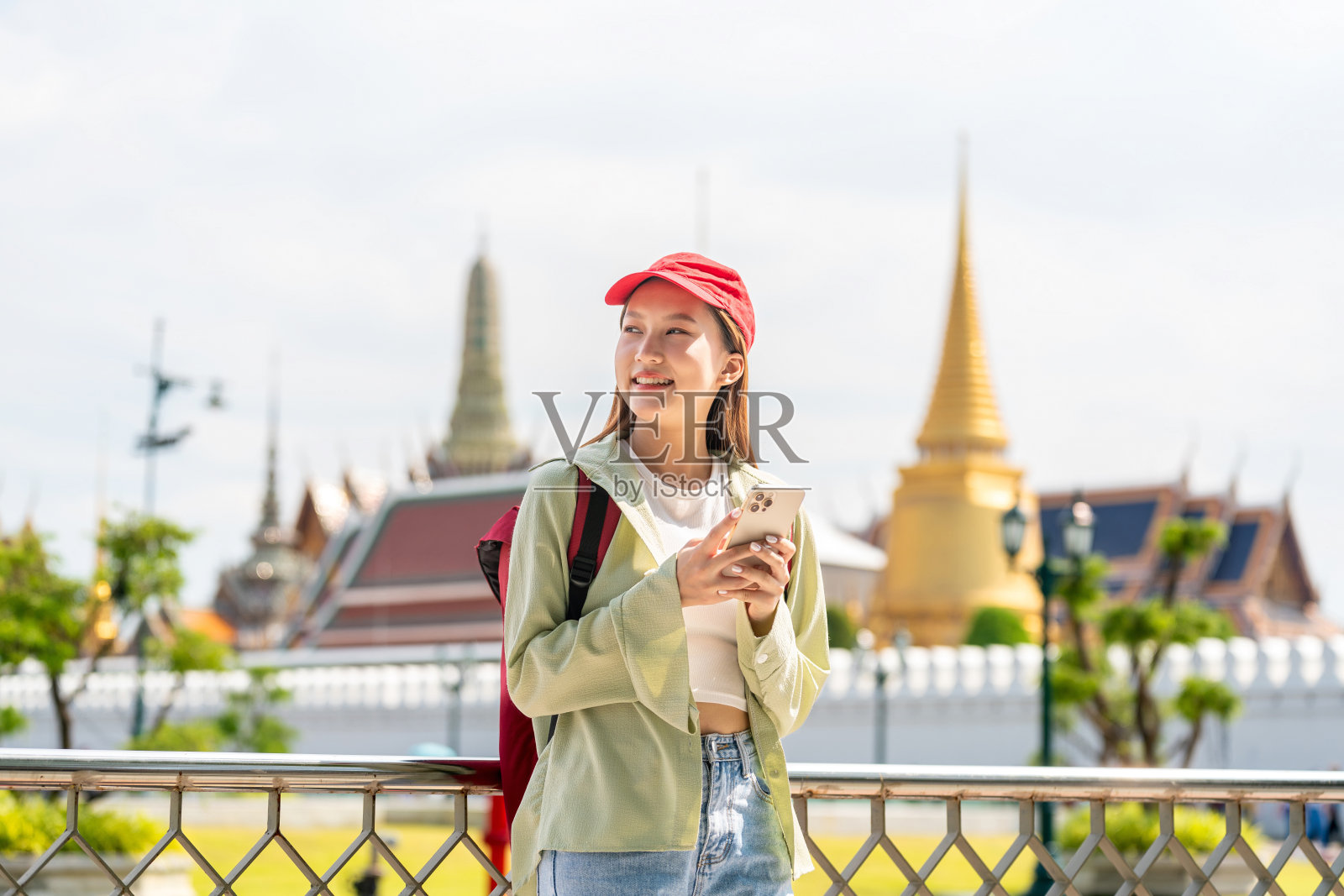 一名亚洲女性在吴佛祖和大皇宫外使用智能手机照片摄影图片