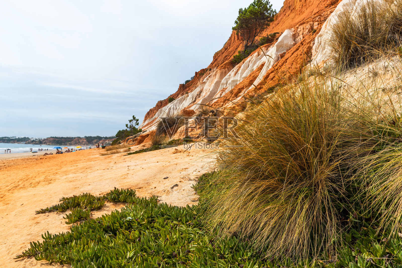 阳光明媚的日子里，葡萄牙阿尔格雷夫沙滩上的红色悬崖照片摄影图片