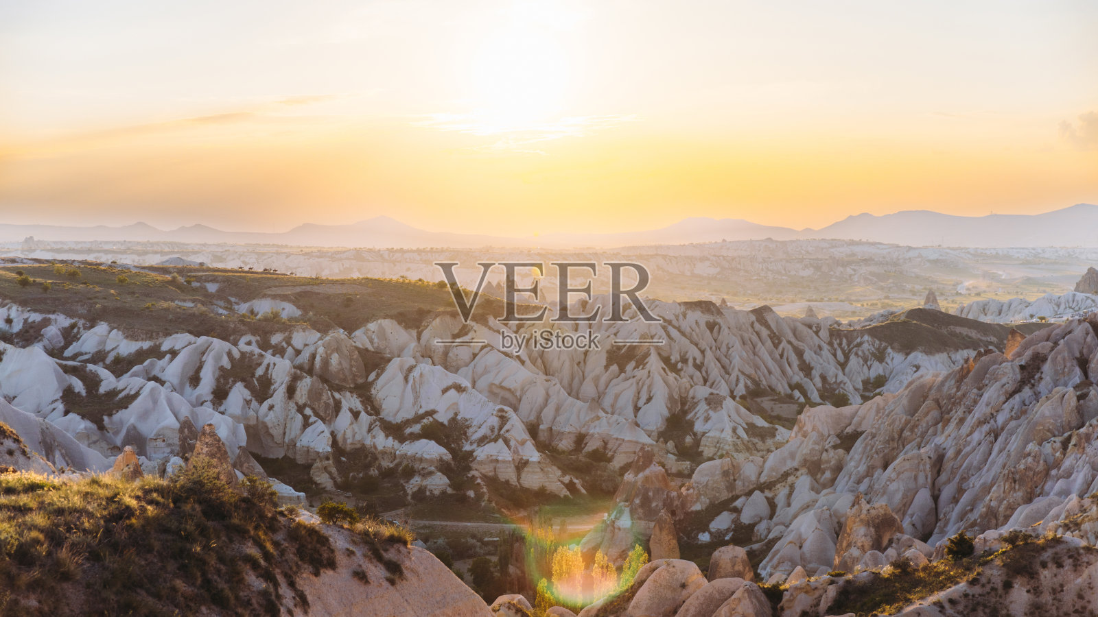 在土耳其卡帕多西亚的田园般的岩层上，戏剧性的日落照片摄影图片