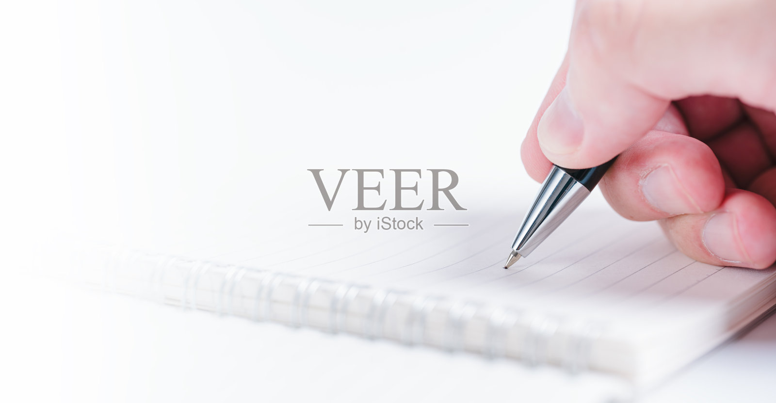 商人用钢笔在办公室白色桌子背景的纸上写字照片摄影图片