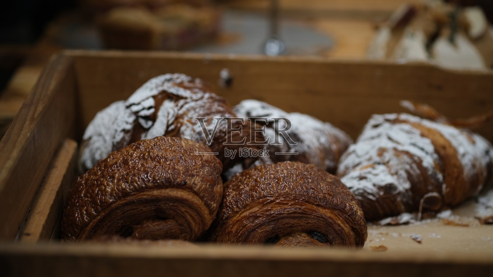 木托盘上的牛角面包。照片摄影图片